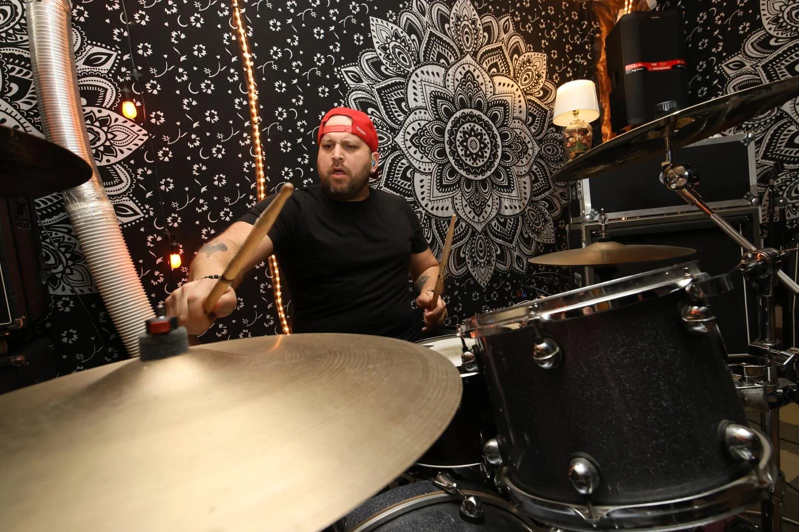 PH Teixeira tocando bateria em seu estúdio durante uma aula
