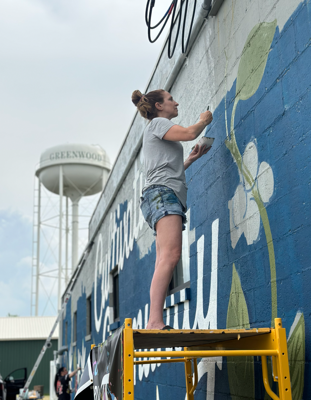 WALS muralists completing the large exterior mural at Amity Coffee