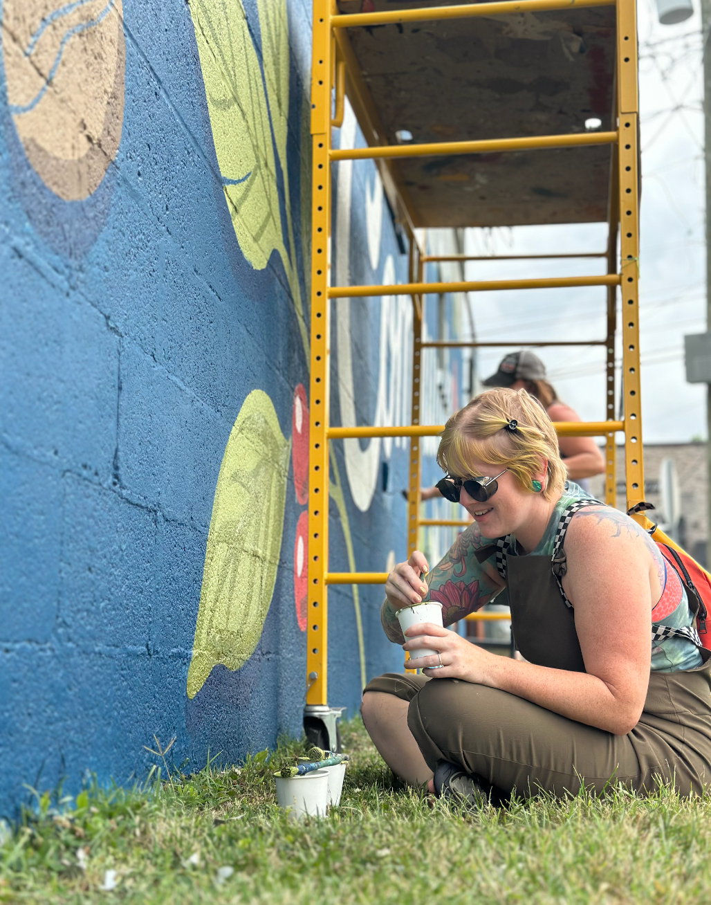 WALS muralists completing the large exterior mural at Amity Coffee