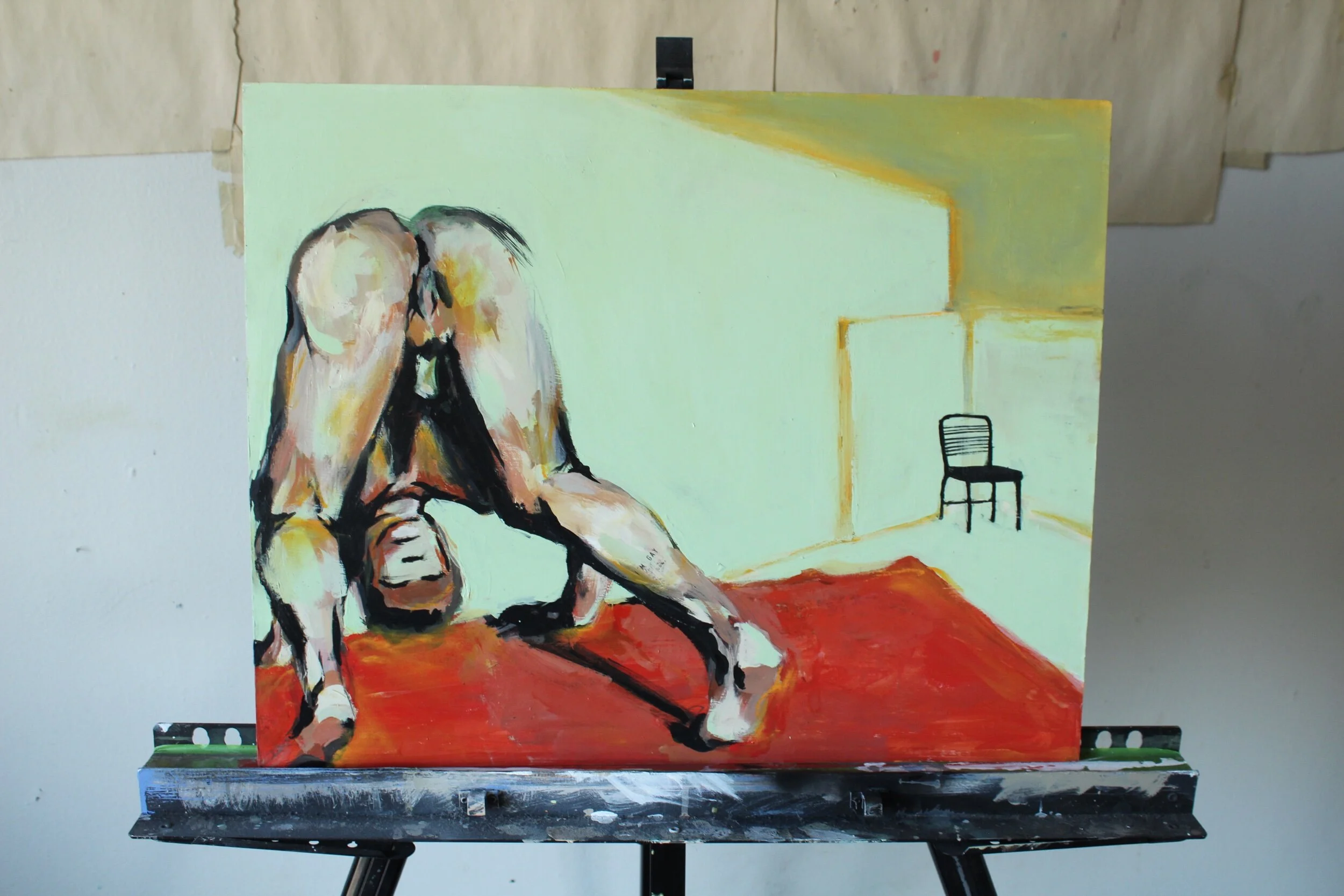 man tries to do a headstand whilst chair is in the corner.