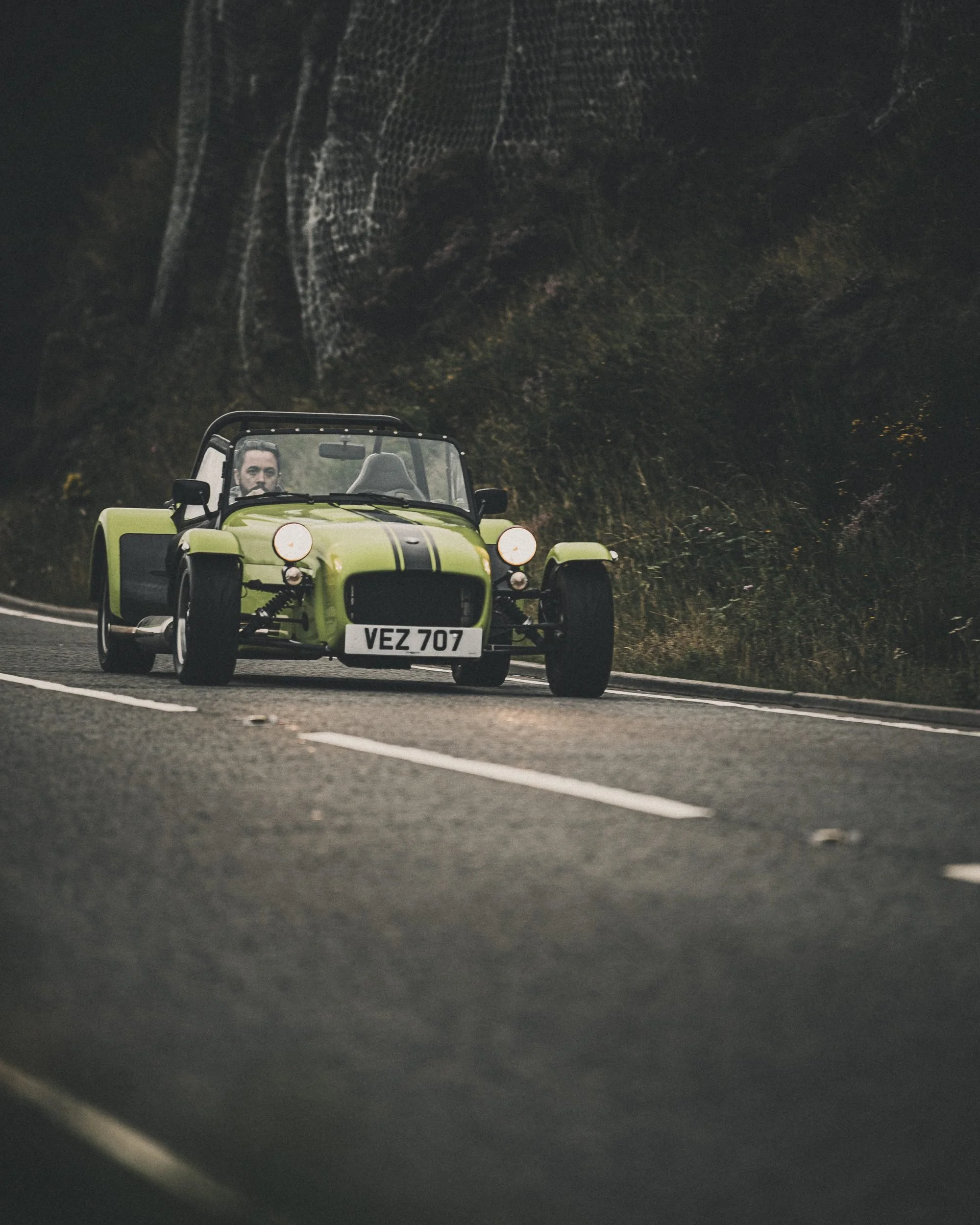 Green Caterham Seven on a mountain road