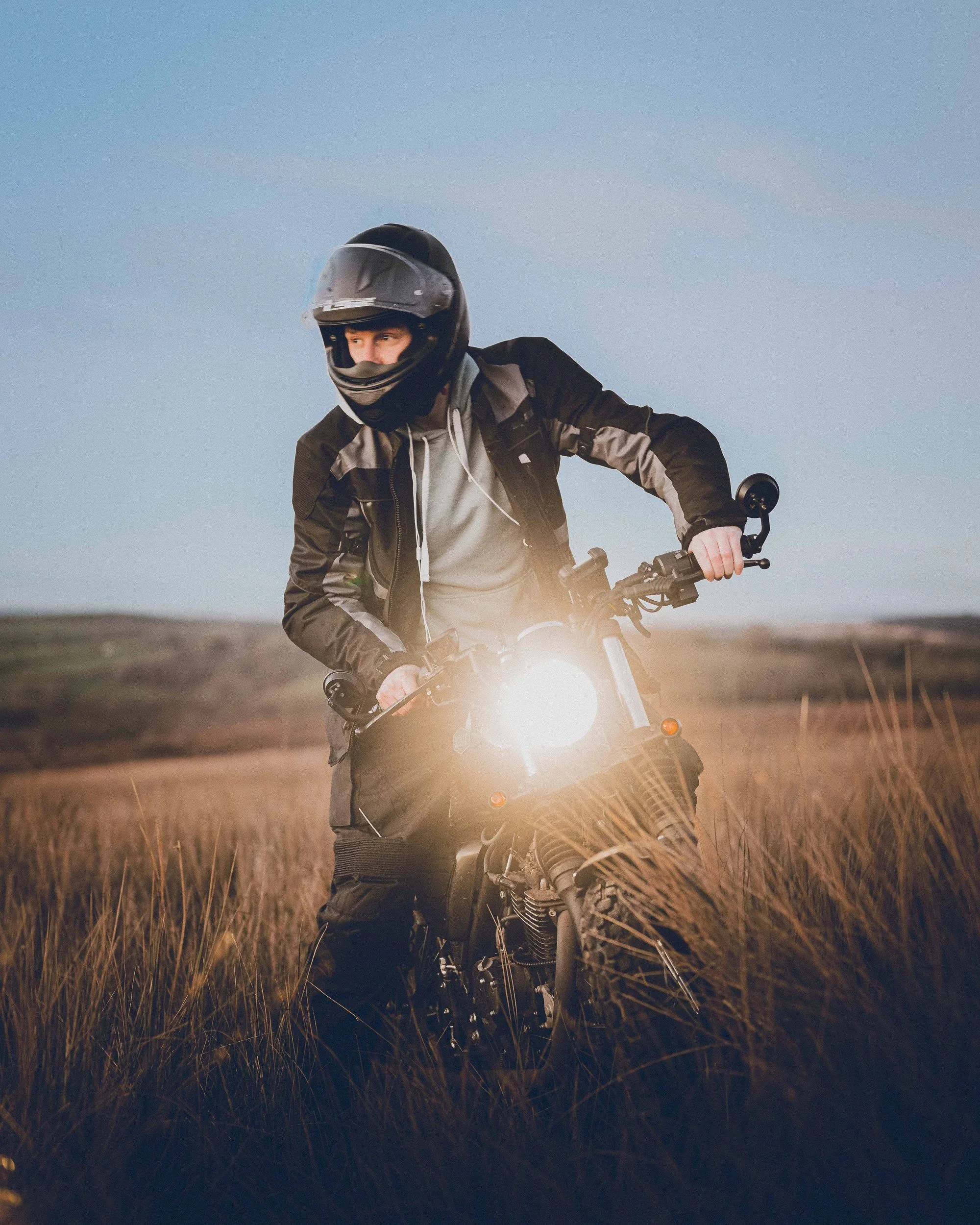 Bullit motorcycle headlight glowing in the long grass, Bannau Brycheiniog