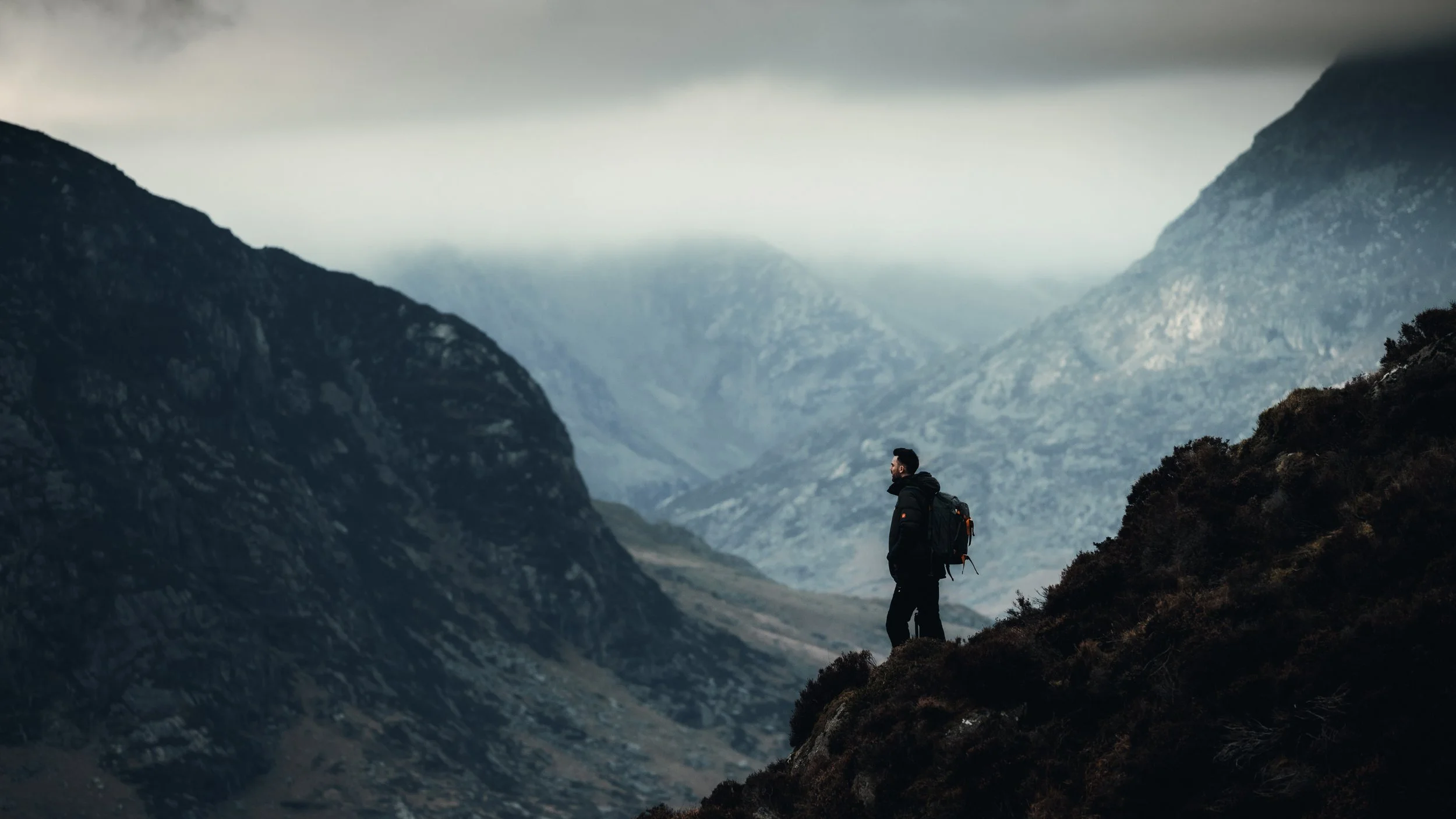 Hiker silhouetted on a ridge above a misty valley