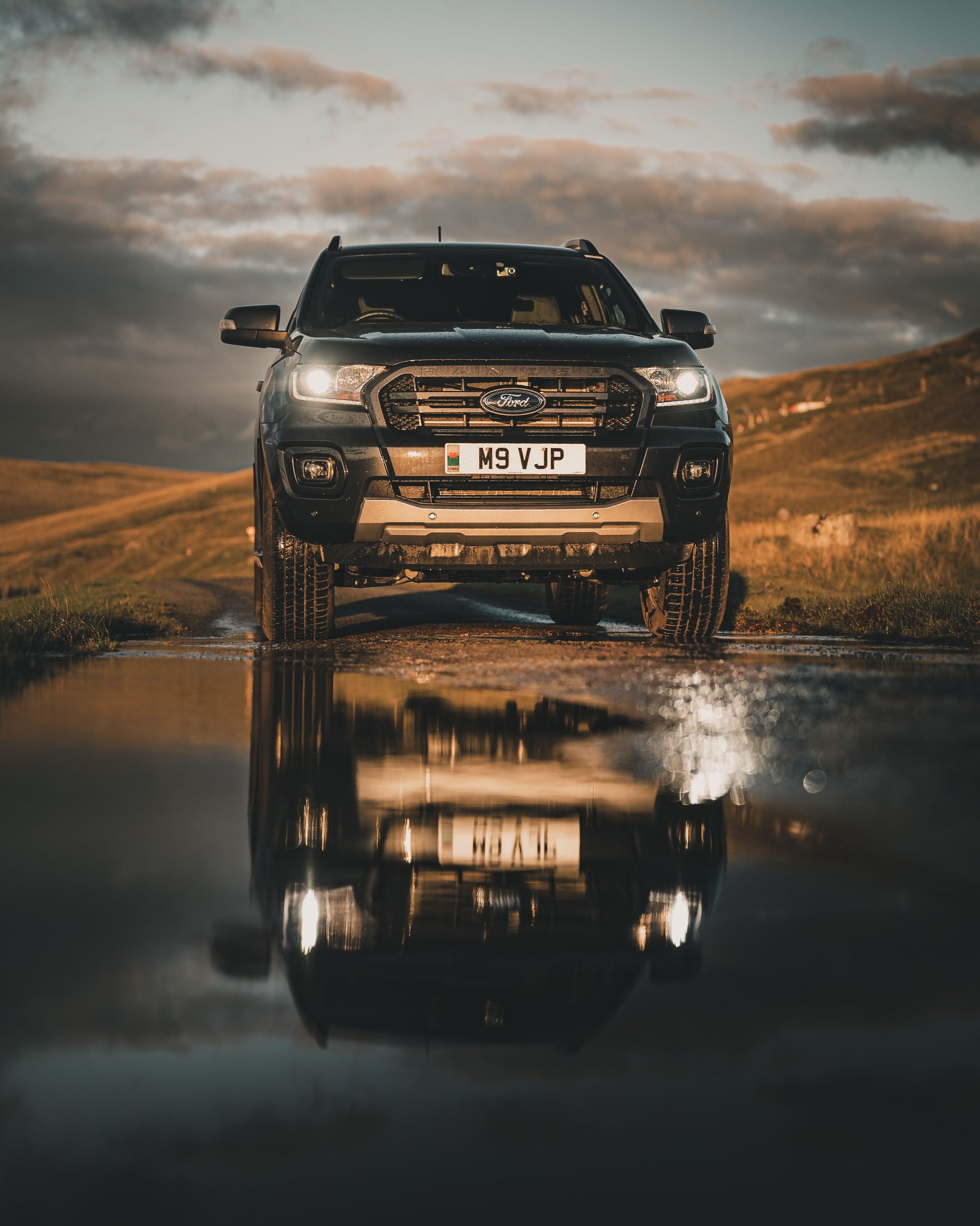 Ford Ranger reflected in a puddle at golden hour