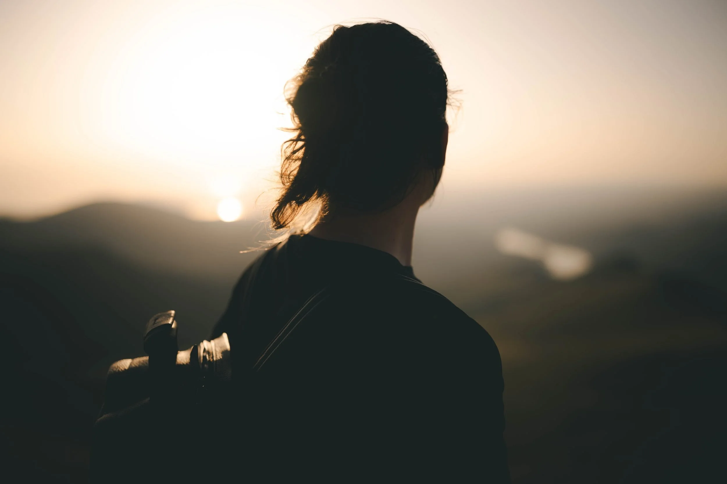 Hiker silhouetted against a mountain sunrise, Eryri