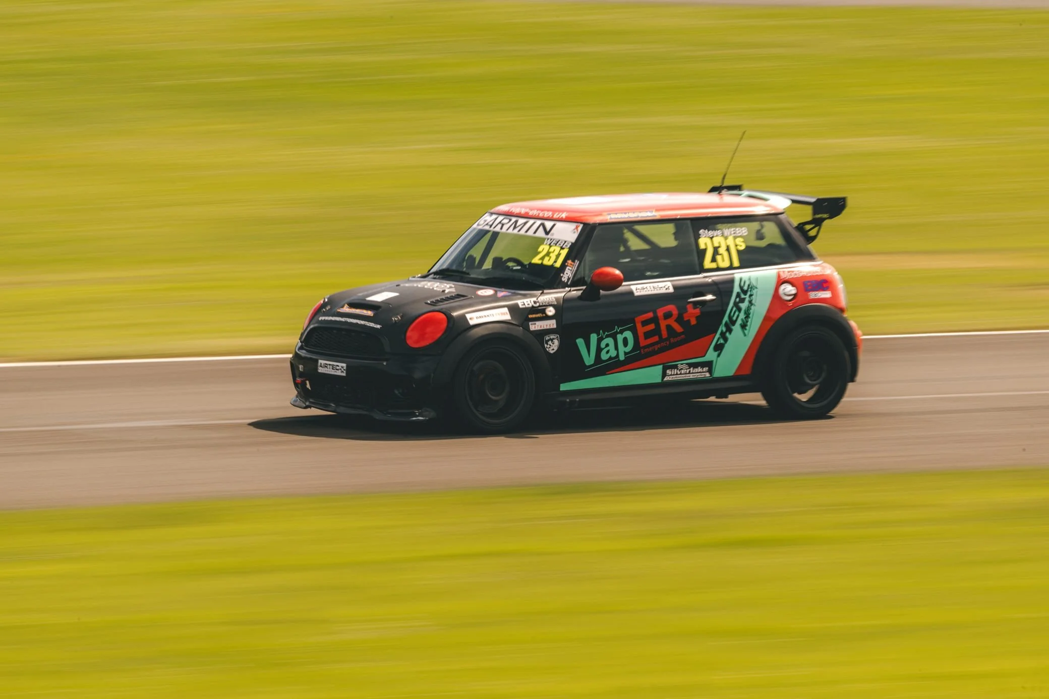 Mini race car cornering hard, Pembrey Circuit