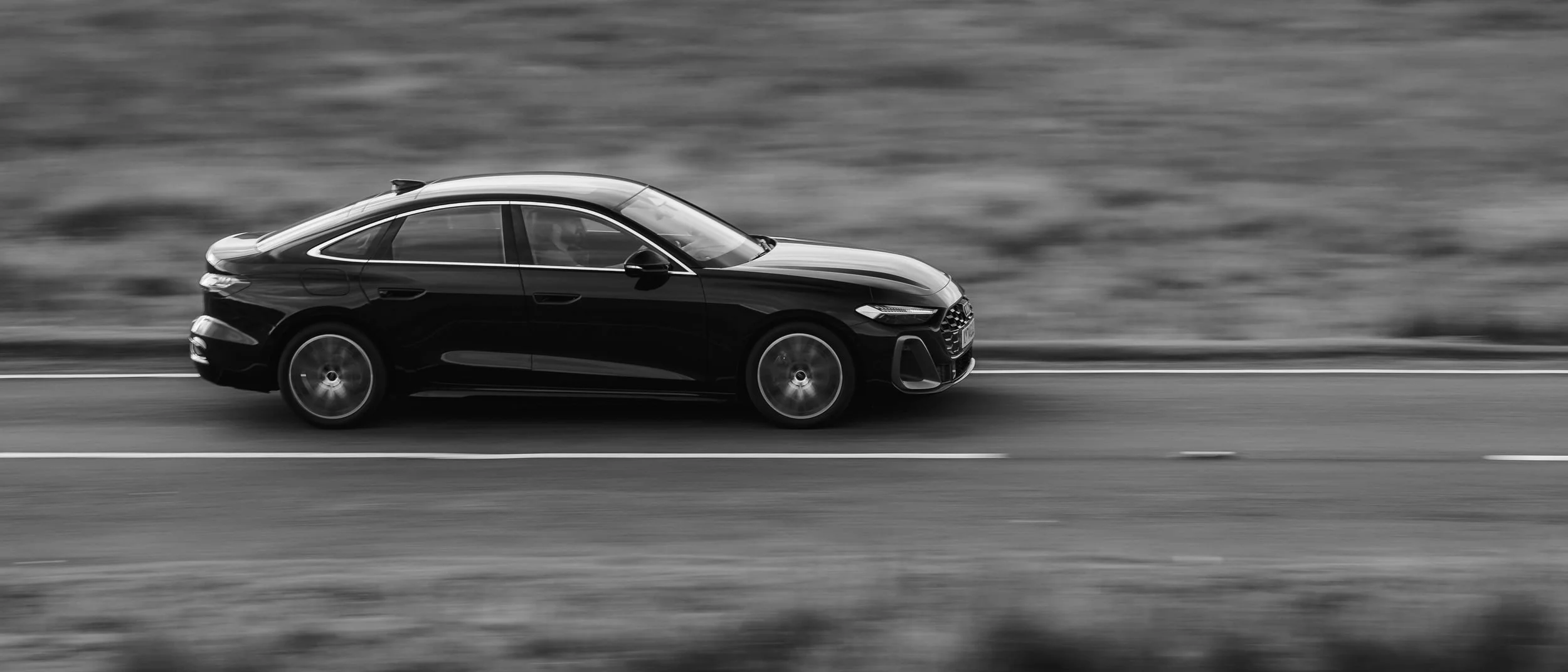Black Audi saloon on an open road, Wales