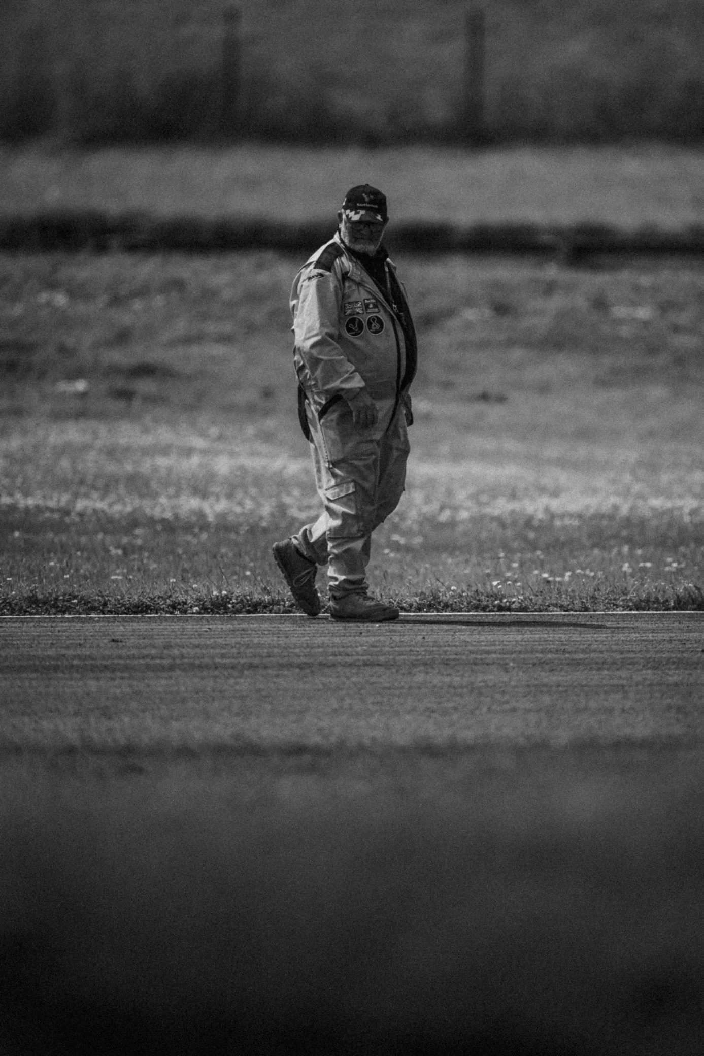 Track marshal walking the circuit in black and white, Pembrey Circuit