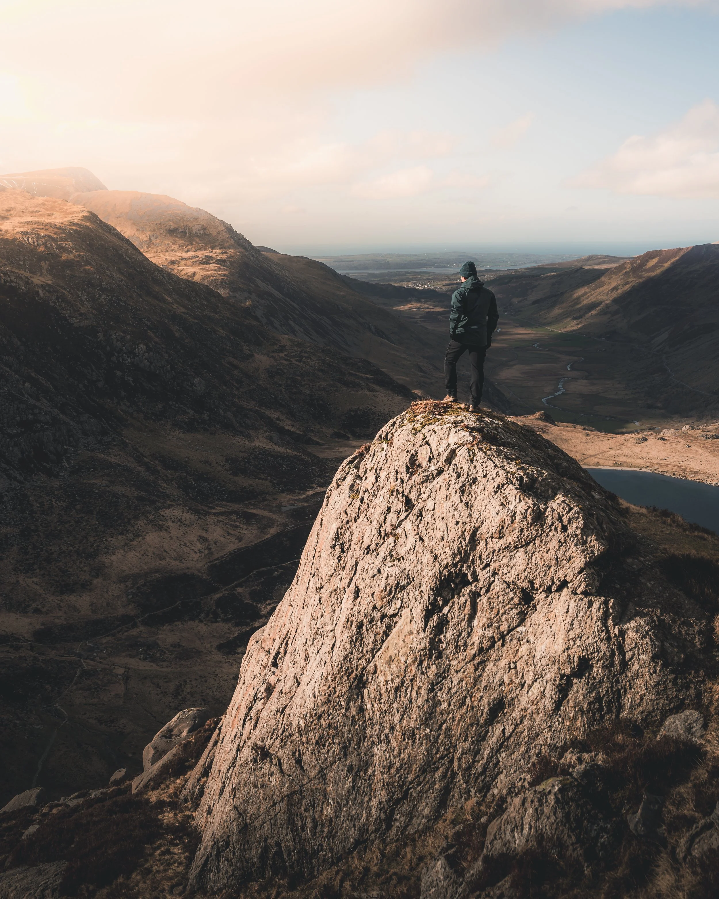 Hiker standing on a rocky outcrop above a valley
