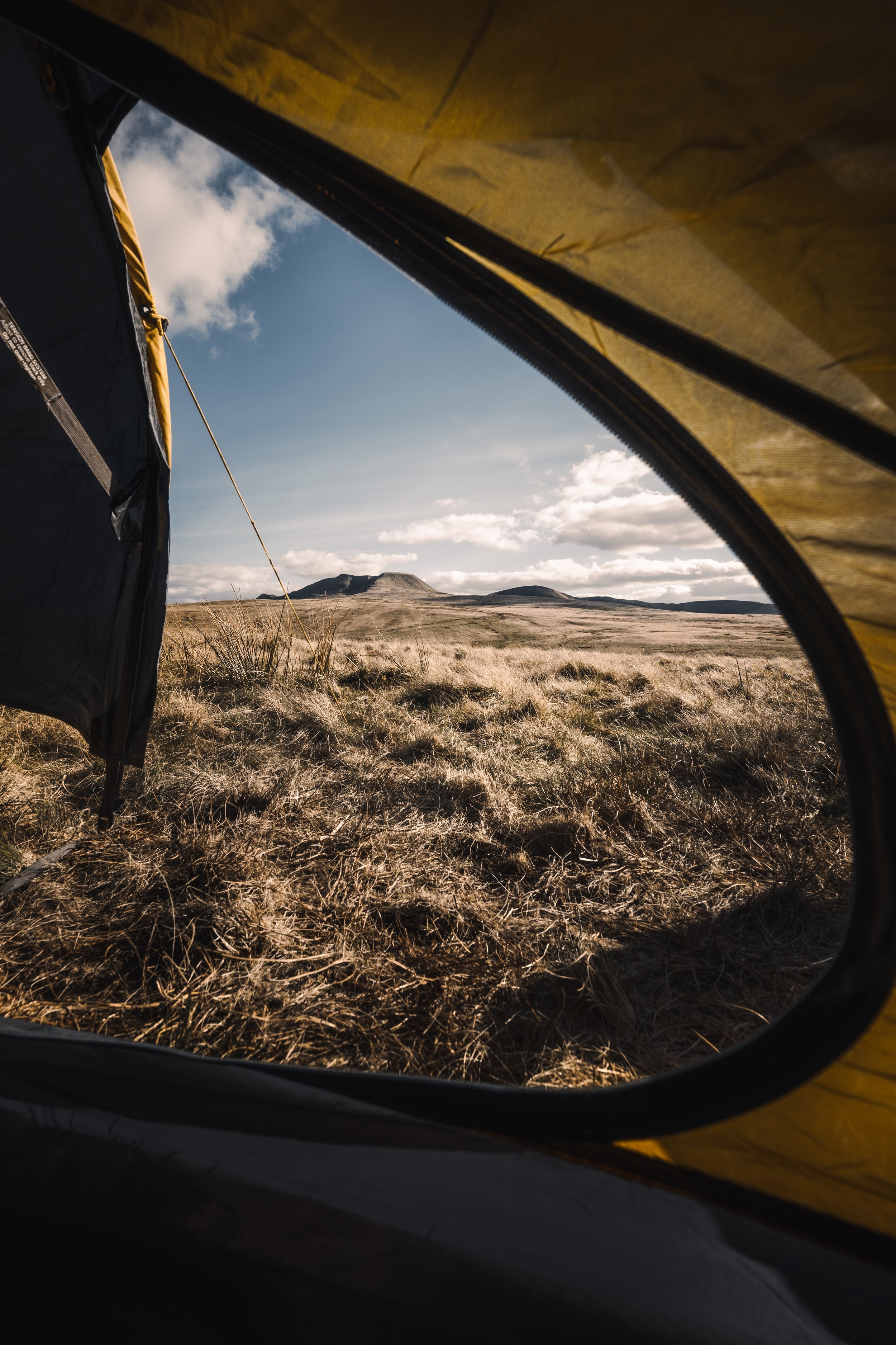 View of moorland through an open tent door