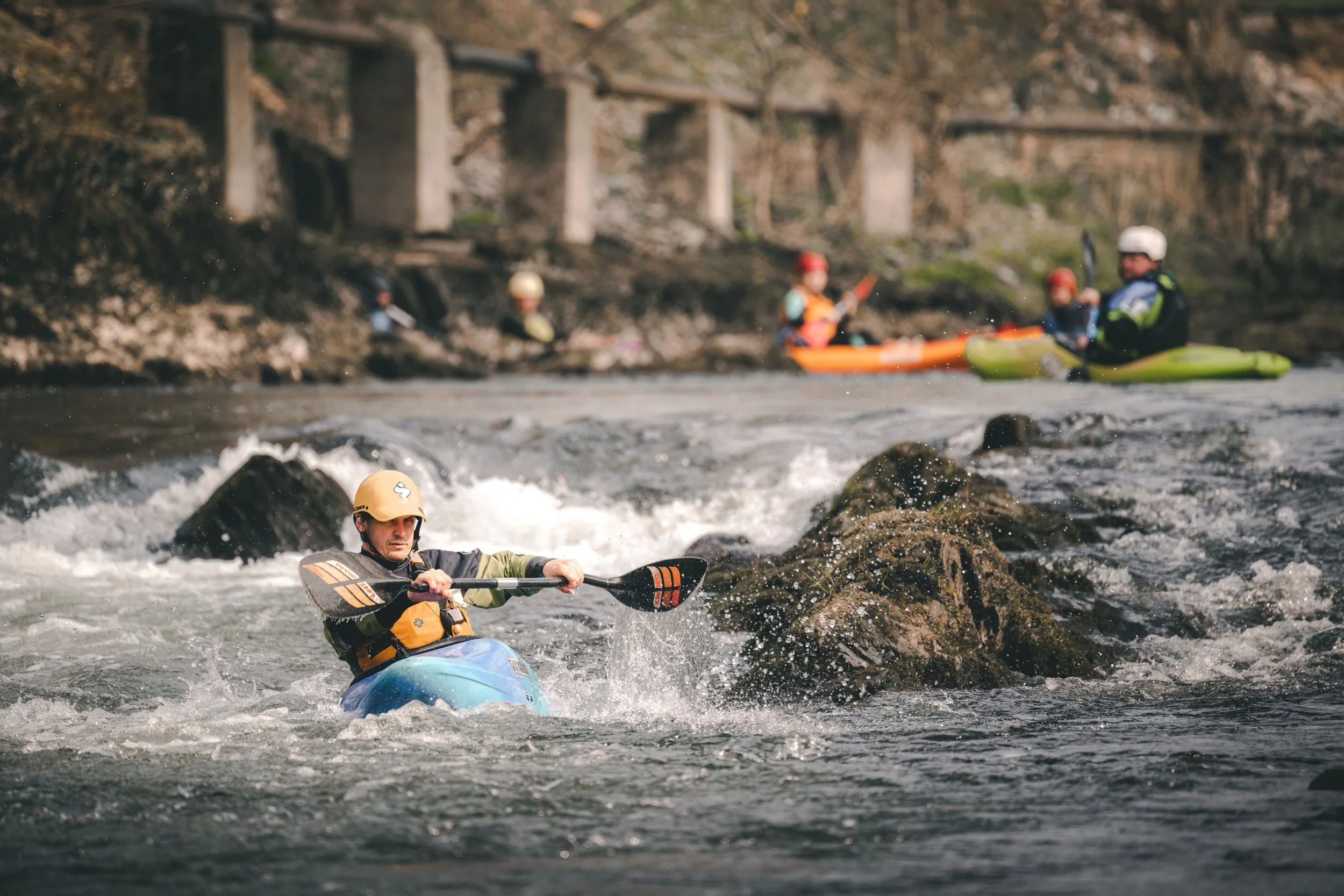 Kayaker paddling through white water rapids