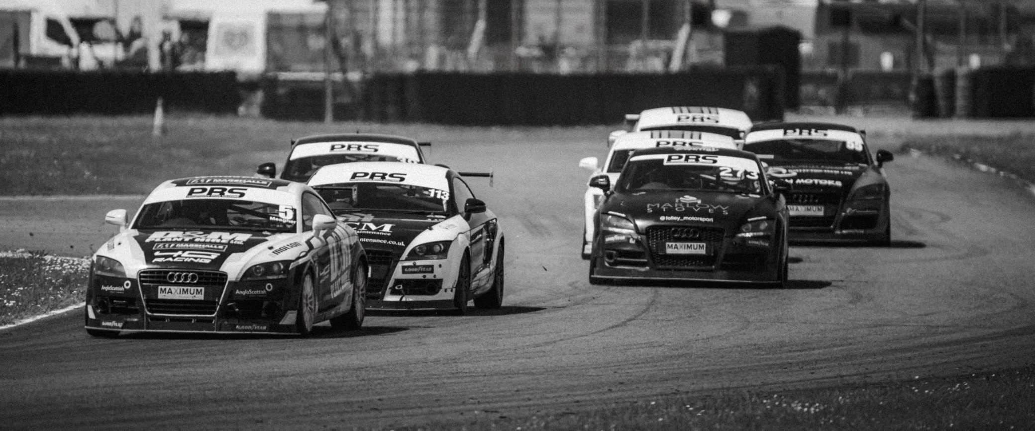 Race cars battling side by side in black and white, Pembrey Circuit