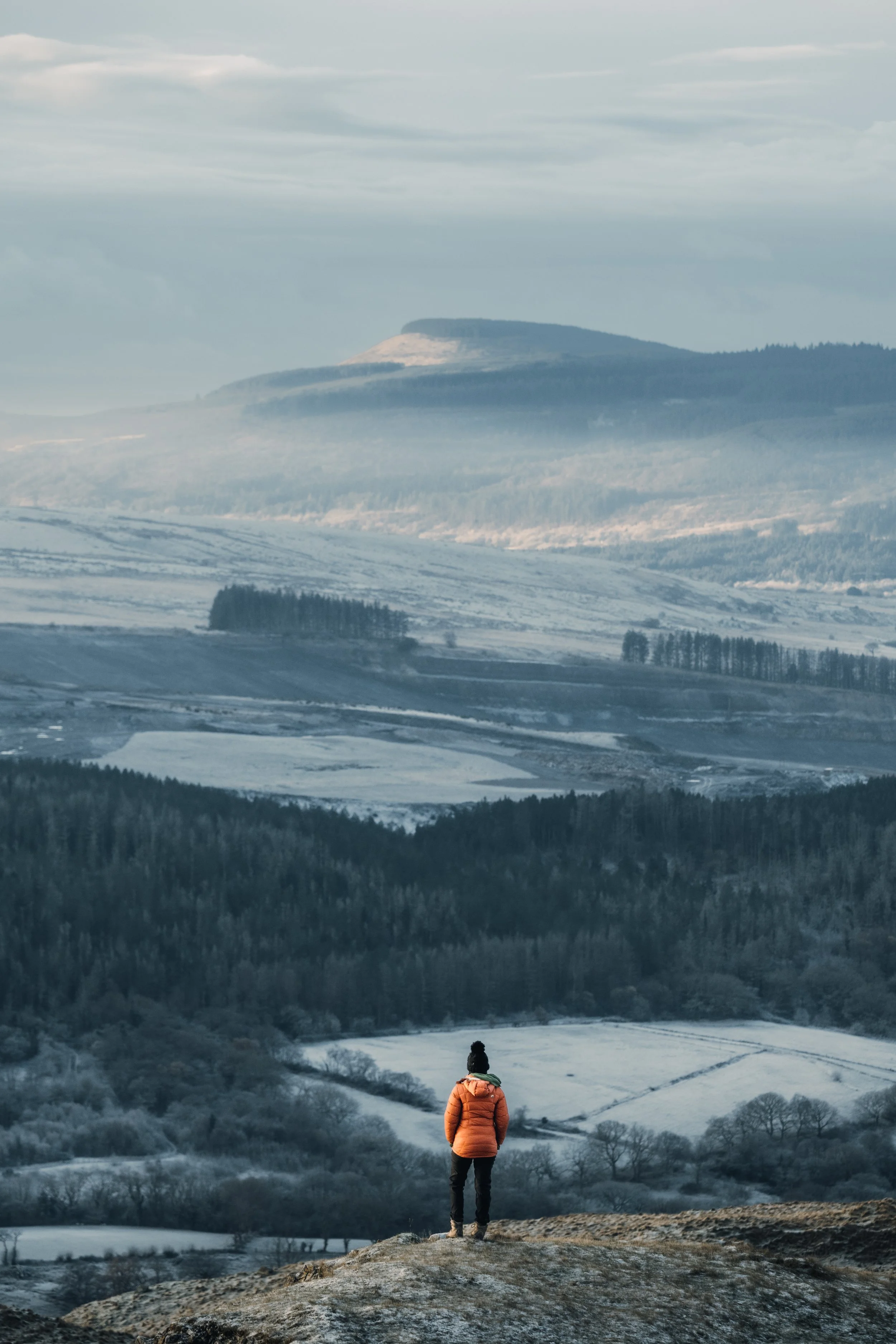 Hiker looking out over a snowy valley