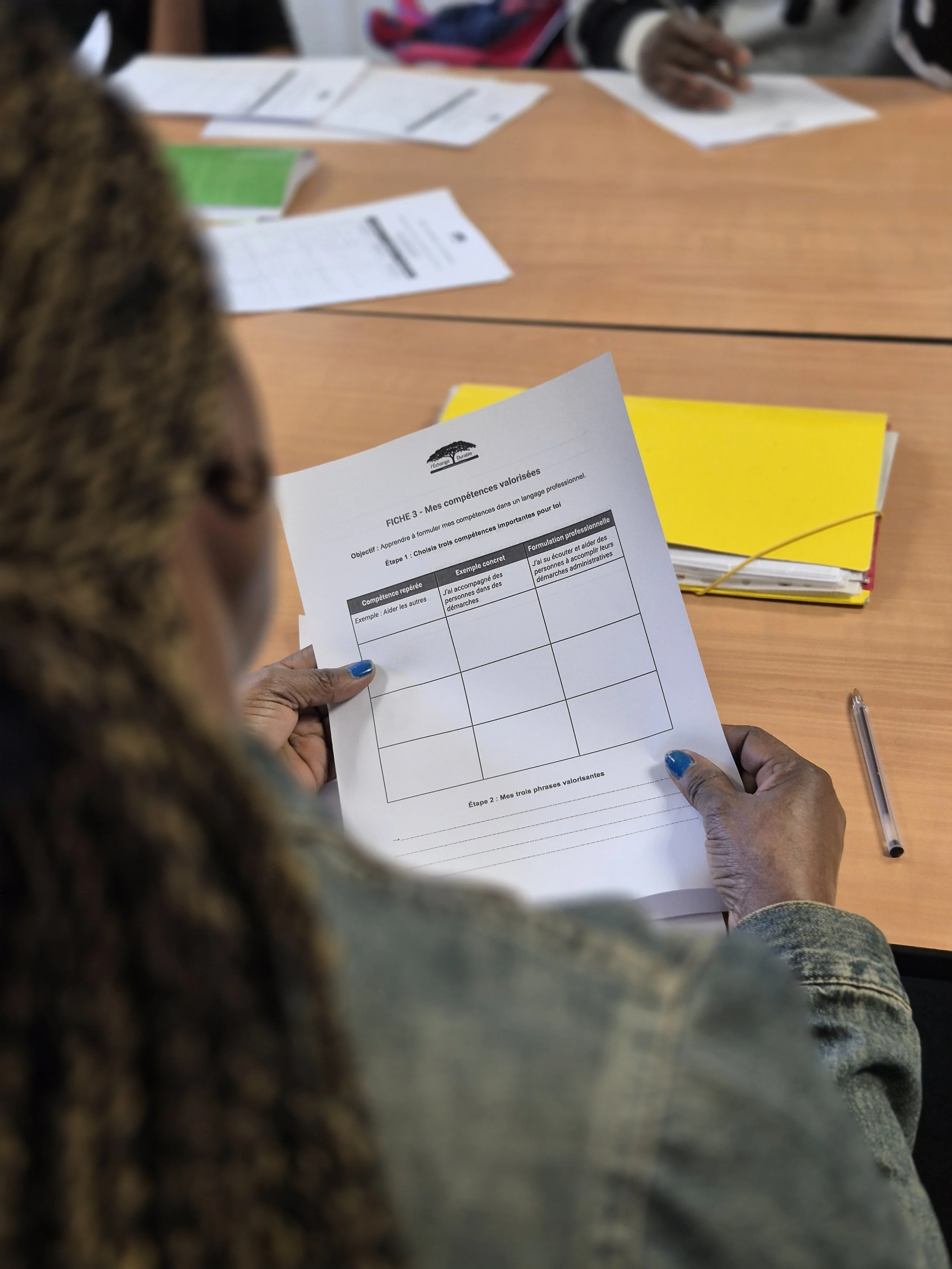 Une personne lit un document lors d'un atelier d'aide à l'insertion professionnelle à destination de réfugiés