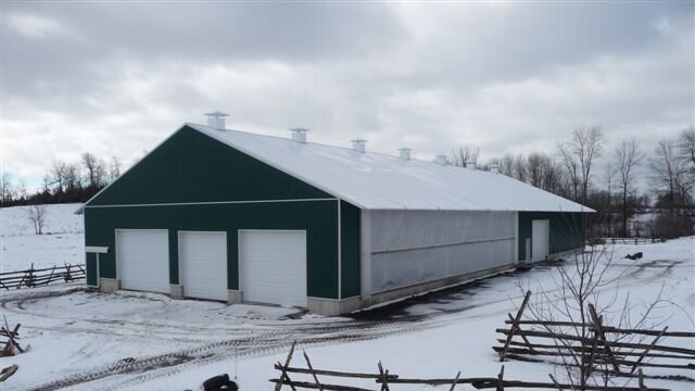 A custom 65’x 156’ fabric roof steel frame dairy barn in Selby, Ontario.