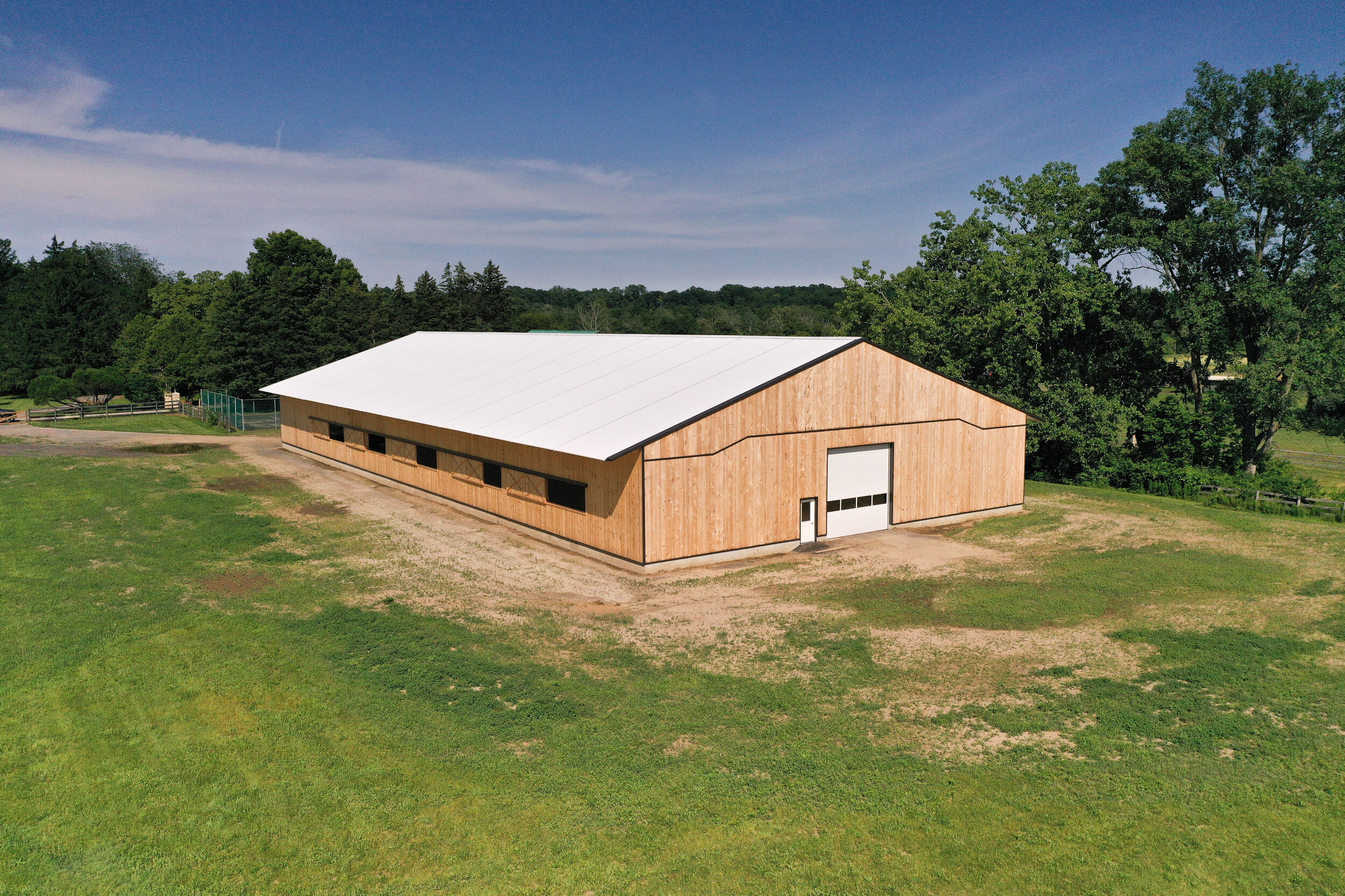 A custom 80’ x 184’ fabric roof wooden riding arena in Delaware, Ontario.