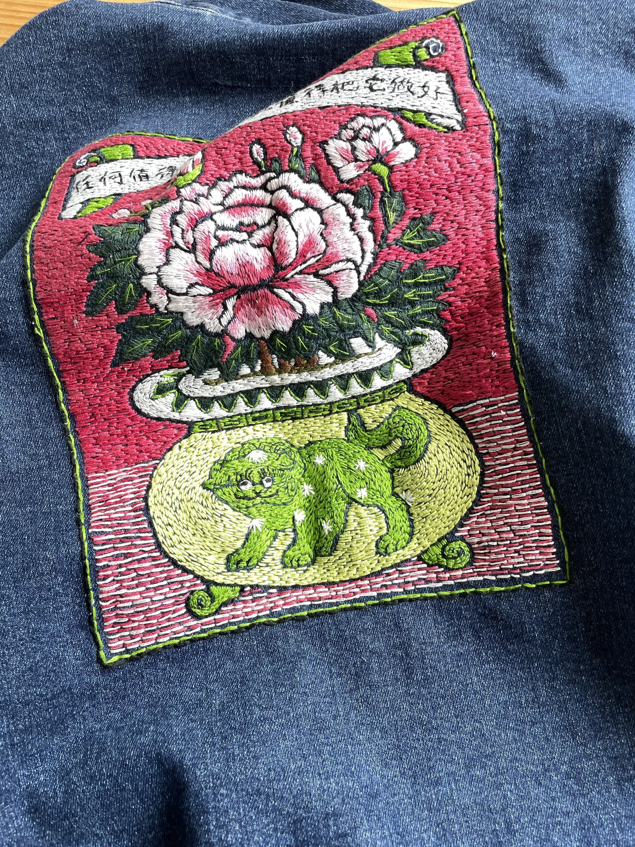 Embroidered flower in a vase on a denim jacket