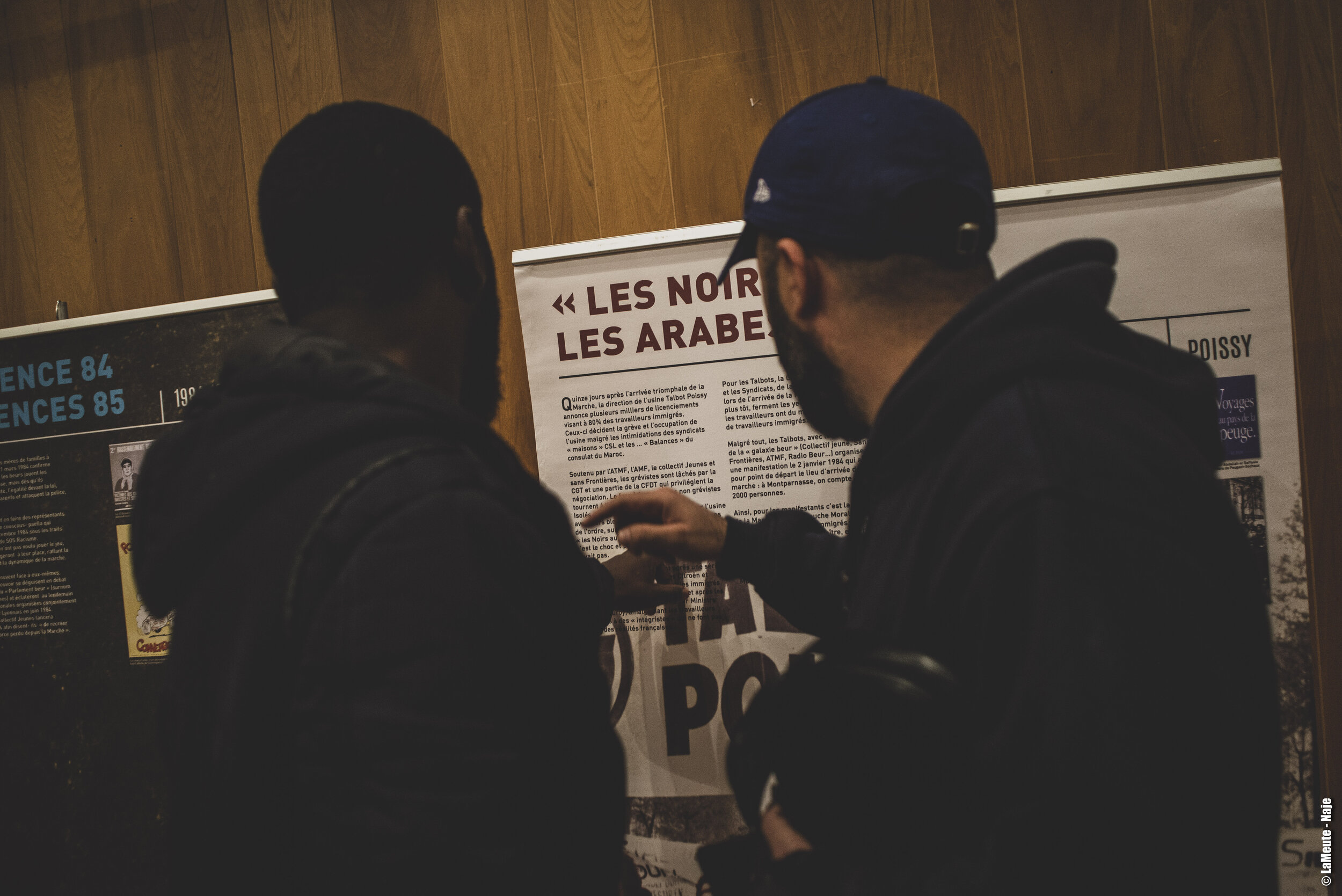   Amidou et Ghezali discutent autour d’un panneau intitulé “les noirs au four, les arabes à la Seine”. Deux semaines après l’arrivée de la Marche pour l’Egalité dans la capitale, une grande partie des travailleurs immigrés des usines Talbot à Poissy 