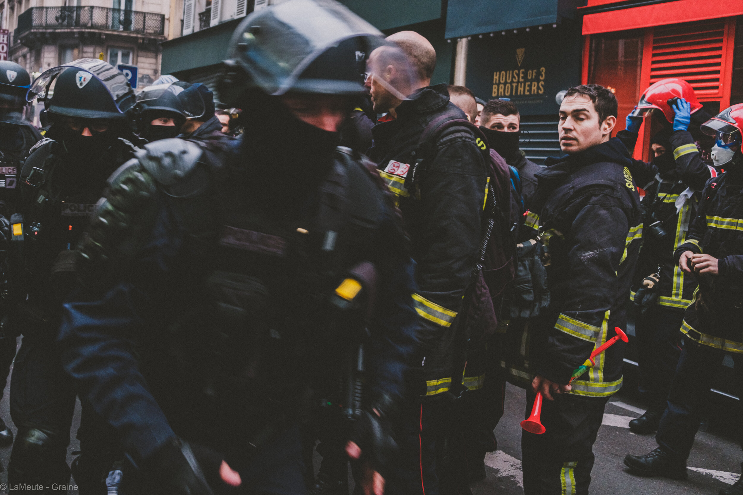  Dans une rue perpendiculaire au boulevard Magenta, des pompiers tentent d’échapper à la souricière. Casqués, ils s’avancent d’un pas décidé vers une ligne de policiers. Les policiers s’avancent à leur tour, et ignorent les pompiers contrairement à c