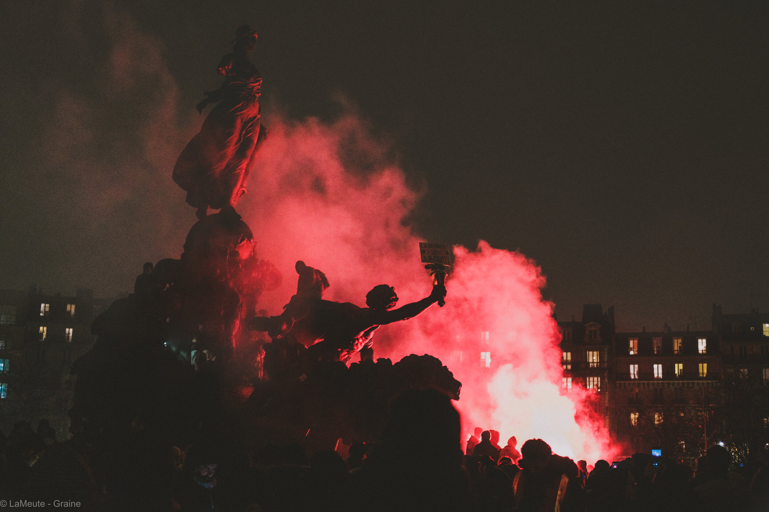  Sur la place de la Nation, euphorie générale. Les fumigènes des cheminot.es plongent la place dans le rouge, et le noir. © LaMeute - Graine 