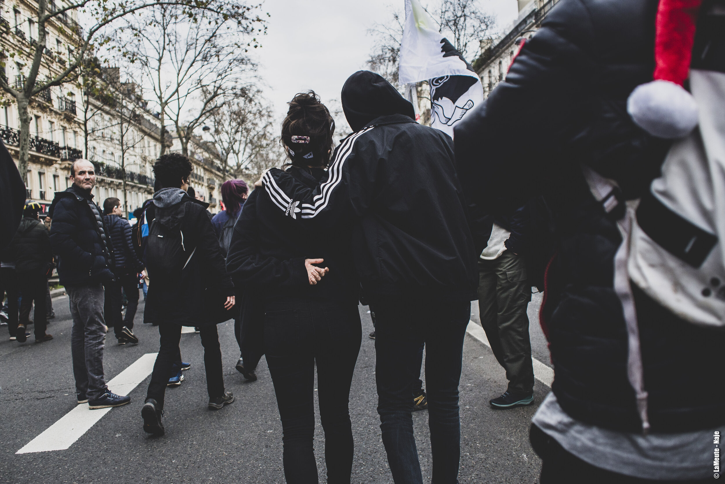   Bras dessus, bras dessous, deux manifestant•es avancent au milieu du cortège.  ©LaMeute - Naje 