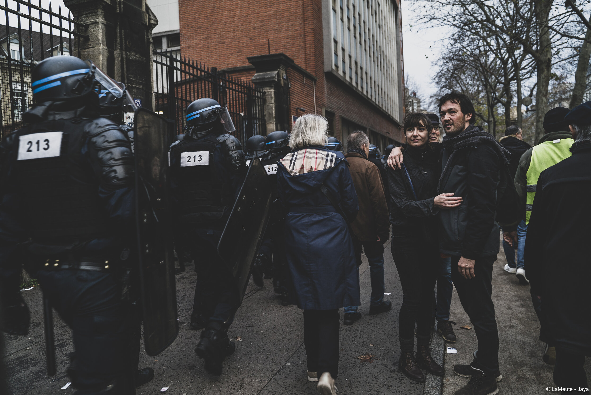   Une lignée de CRS et de BRAV encadre de chaque côté du trottoir le cortège de manifestant-es.  ©LaMeute - Jaya 