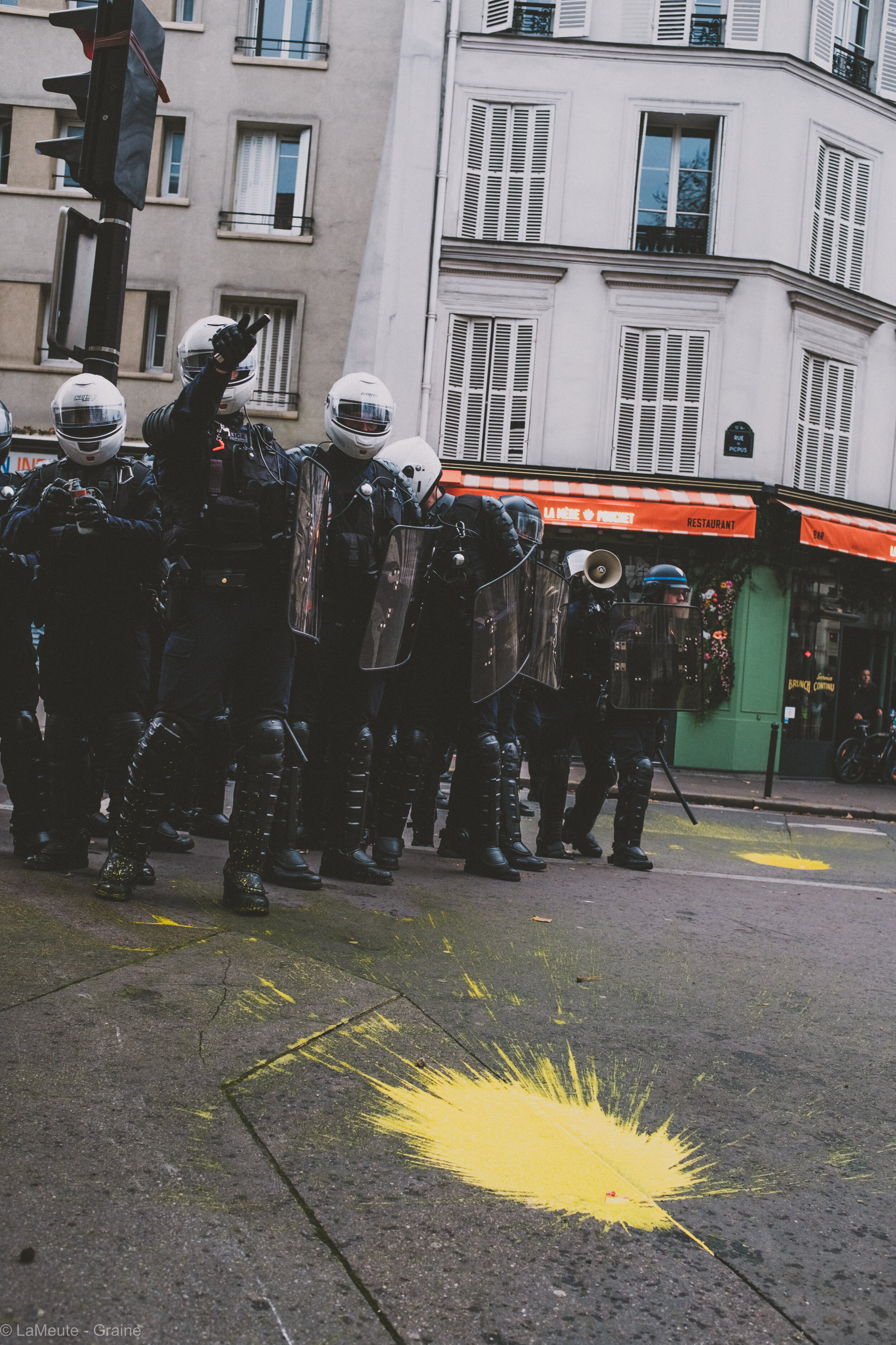  Revenu à son poste initial, l’escadron des BRAV-M menace : une nouvelle charge arrive. Le policier qui dégoupille sa grenade à gauche de la photo va totalement rater son tir quelques secondes plus tard, la grenade percutant lamentablement le mur sur