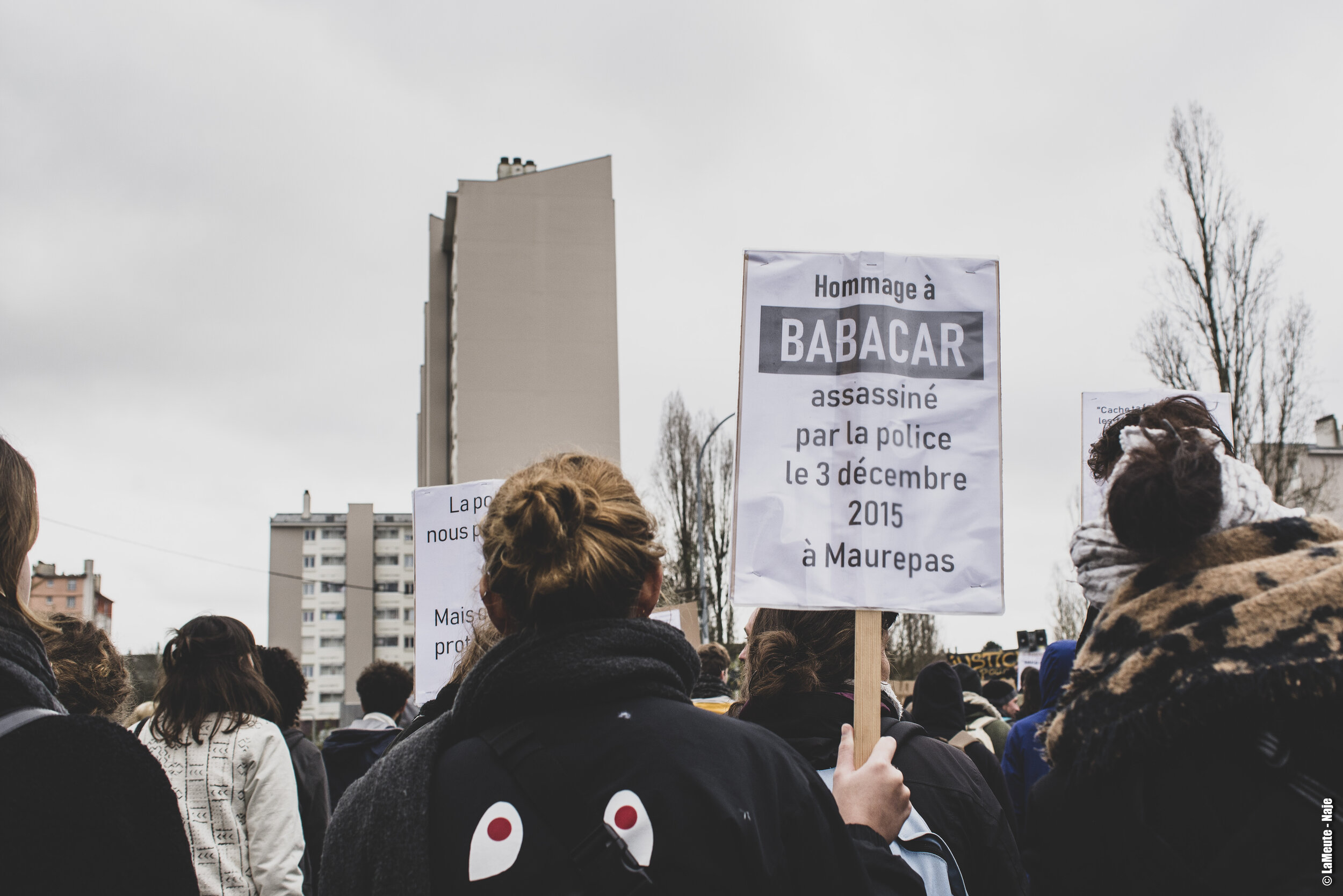   De nombreux•ses manifestant•es venu•es soutenir le collectif justice et vérité pour Babacar Gueye portent des pancartes. Celle-ci au premier plan rappelle les circonstances de la mort de Babacar.  ©LaMeute - Naje   