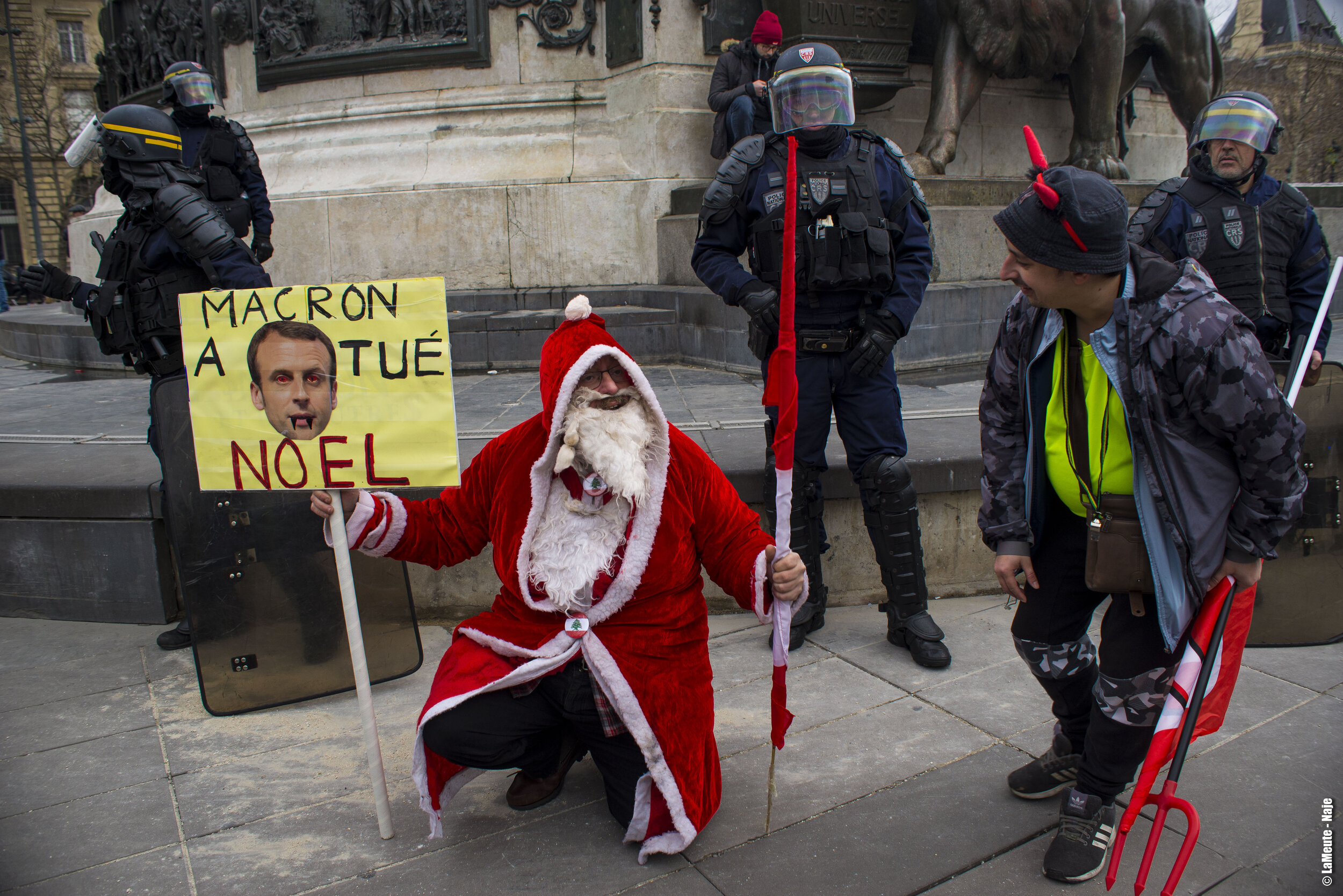   Arrivé à la hauteur de République, le dispositif policier a choisi de boucler la moitié de la place. Un manifestant déguisé en Père Noël prend la pose devant un cordon de CRS.  ©LaMeute - Naje.      