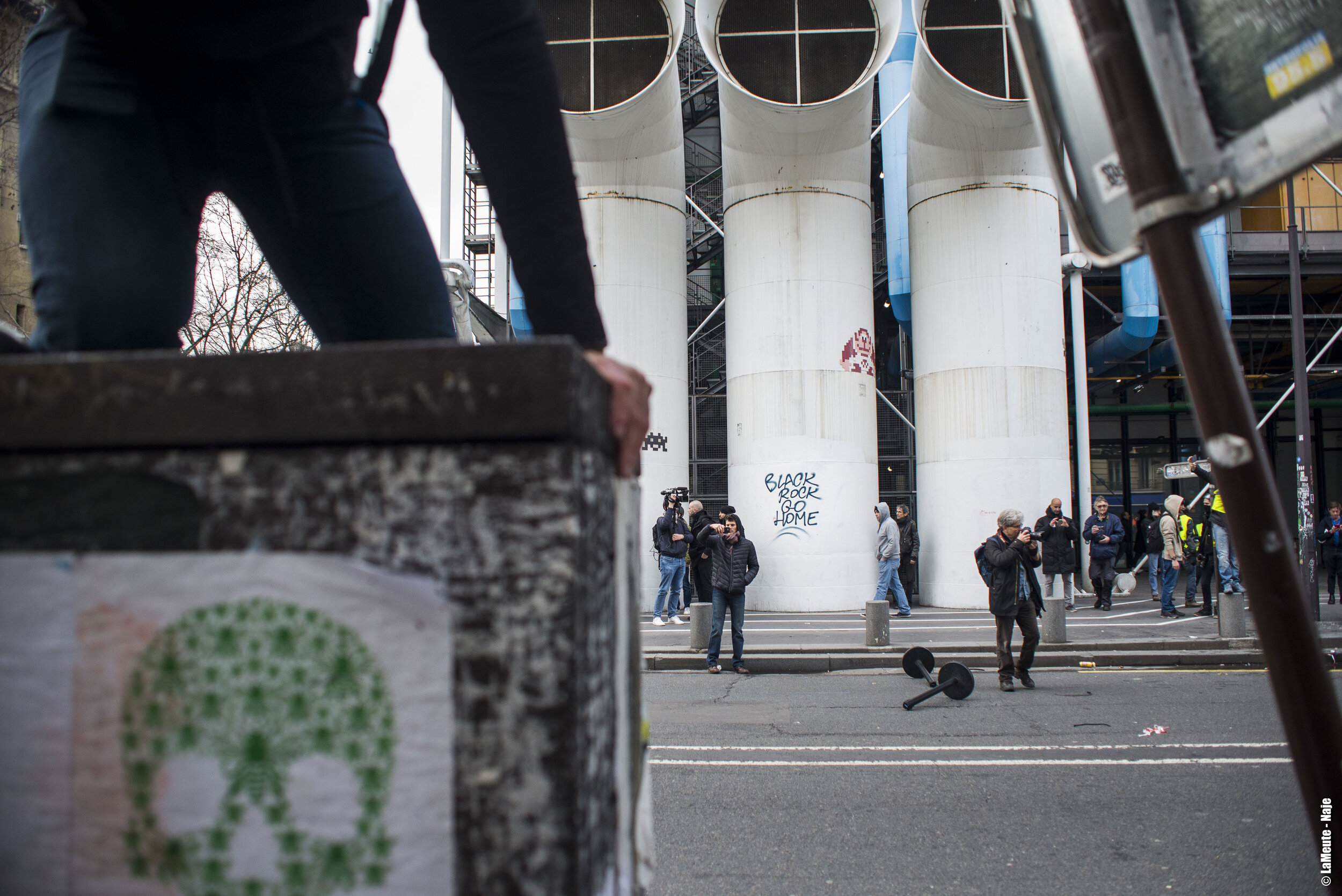   Sur le passage de la manifestation c’est la guerre des mots d’ordres qui se mène. Le « camp » des graffitis populaires versus celui des mots d’ordres publicitaires.  ©LaMeute - Naje.   