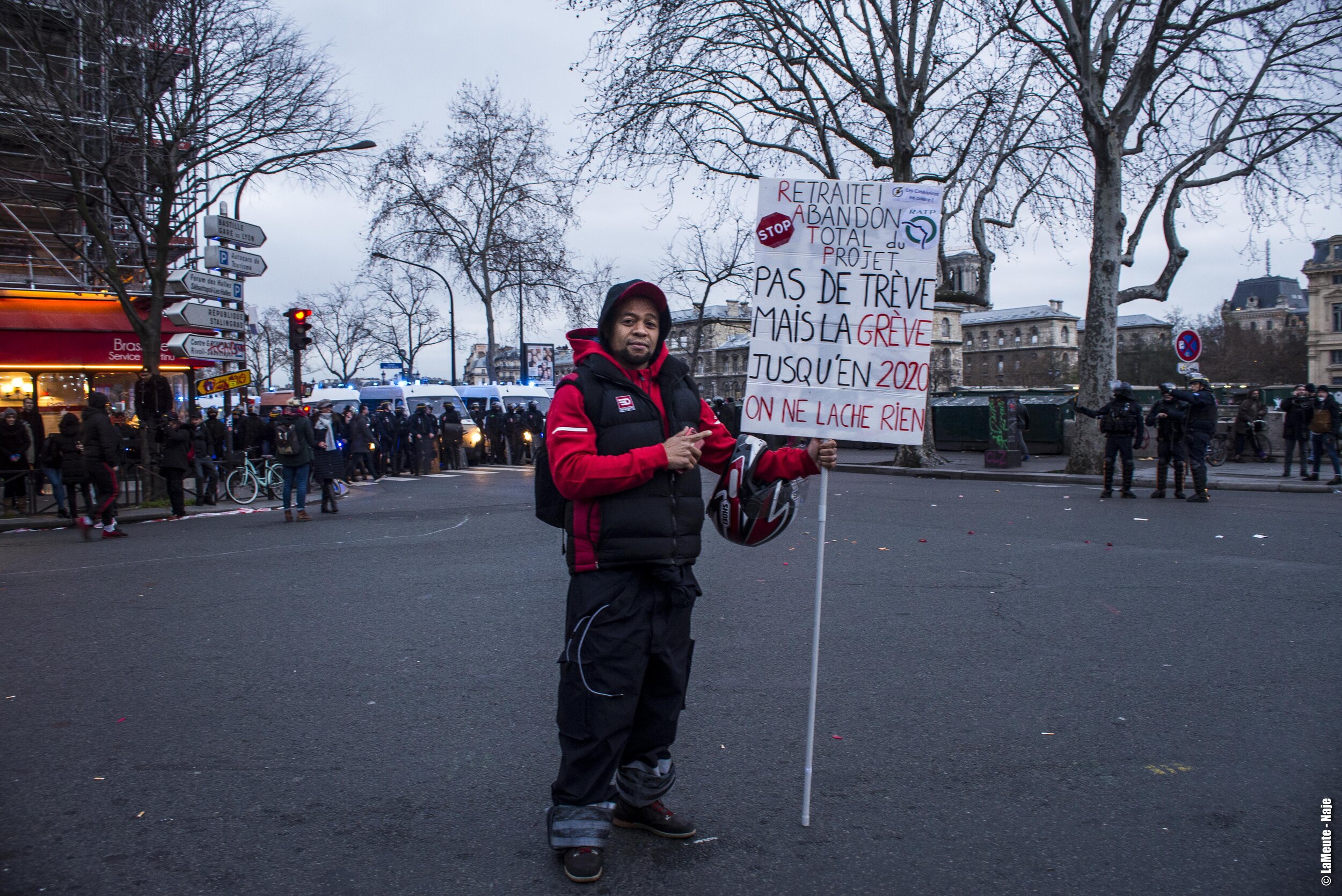   Alors que la place du Châtelet devient peu à peu une souricière, un travailleur de la RATP pose avec sa pancarte . ©LaMeute - Naje. 