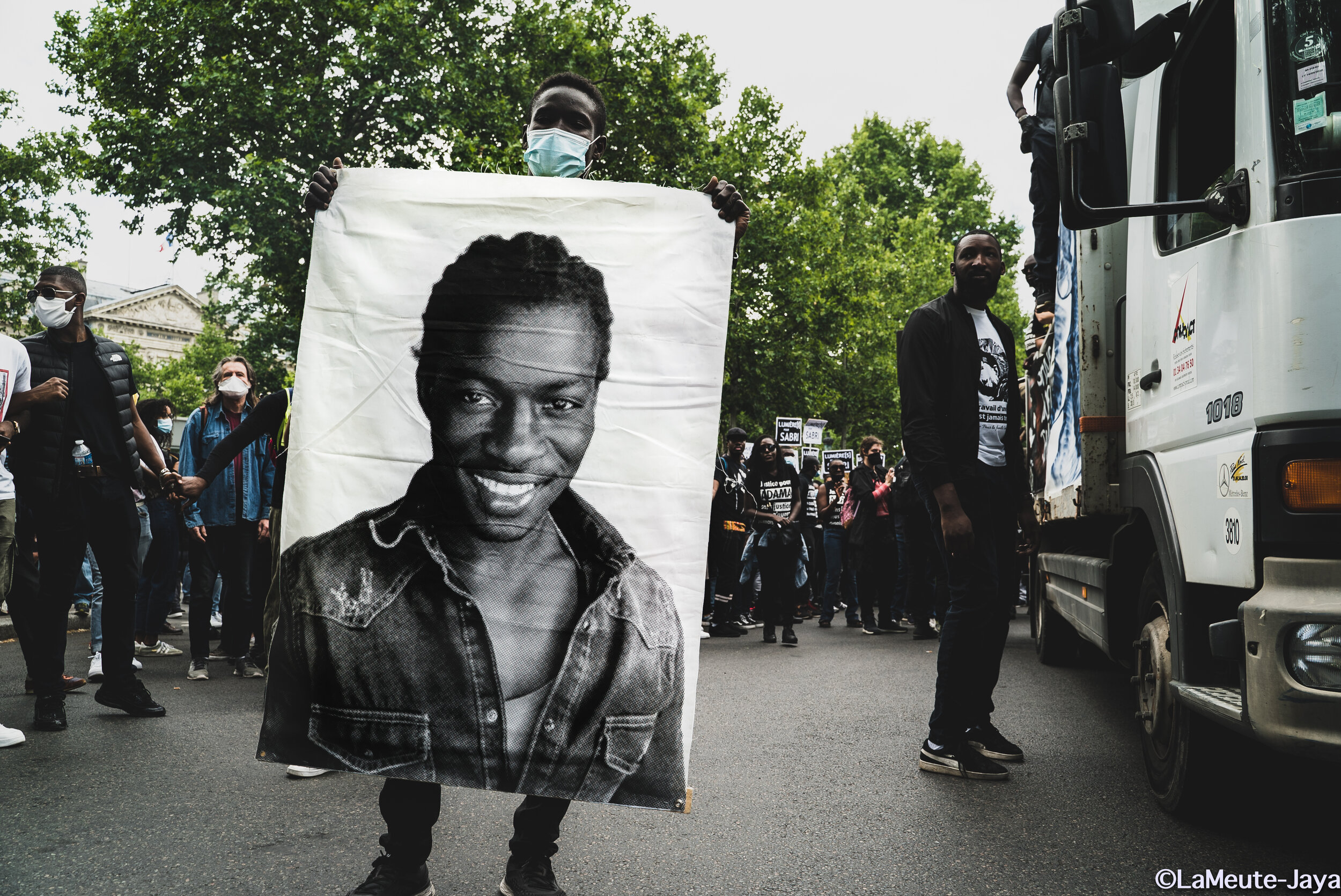   Portrait de Babacar Gueye, tué par les balles de la BAC de Rennes dans le quartier de Maurepas en 2015. Sa soeur, Awa, mène la lutte pour que Justice soit rendue dans la mort de son frère. Au second plan, Makan Kebe, le fils de Mme Kebe; trois memb