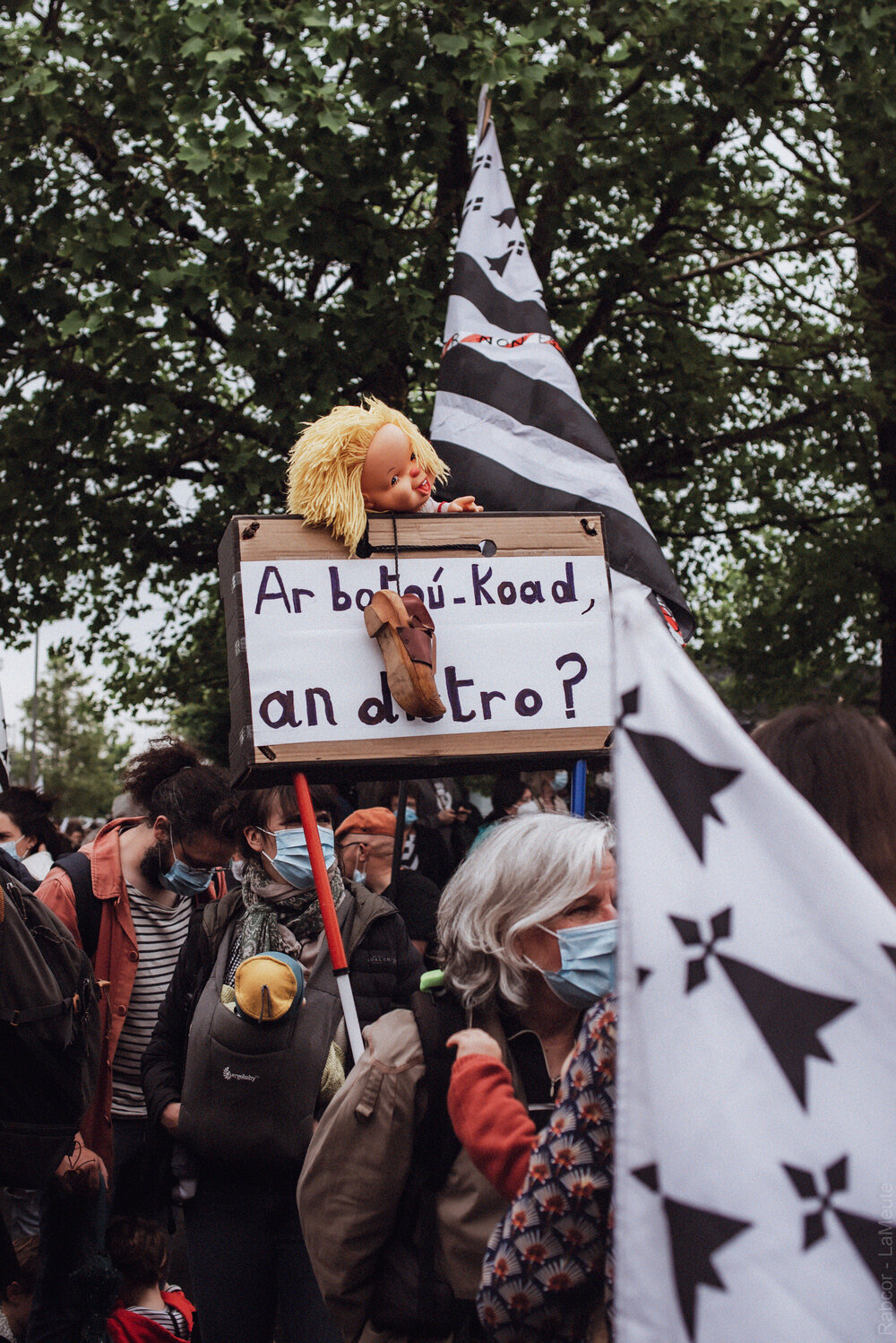  Une manifestante avec une pancarte faisant référence au sabot de bois porté par les enfants ayant parlés breton à l’école. 