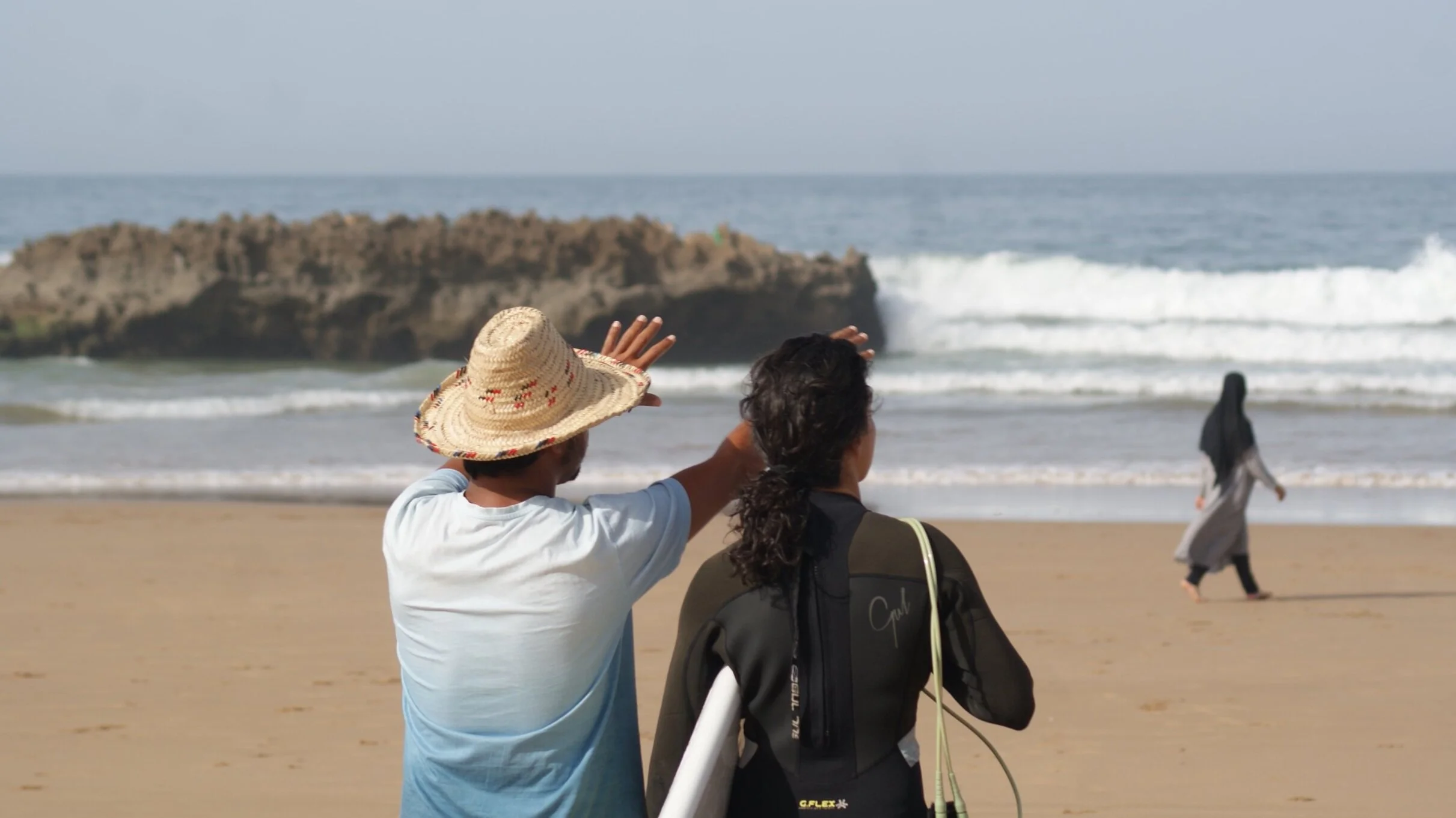 ISA Surf Coach Rachid explainign how to paddle out safely at Crocros surf spot, Tamraght, Taghazout Bay, Morocco.