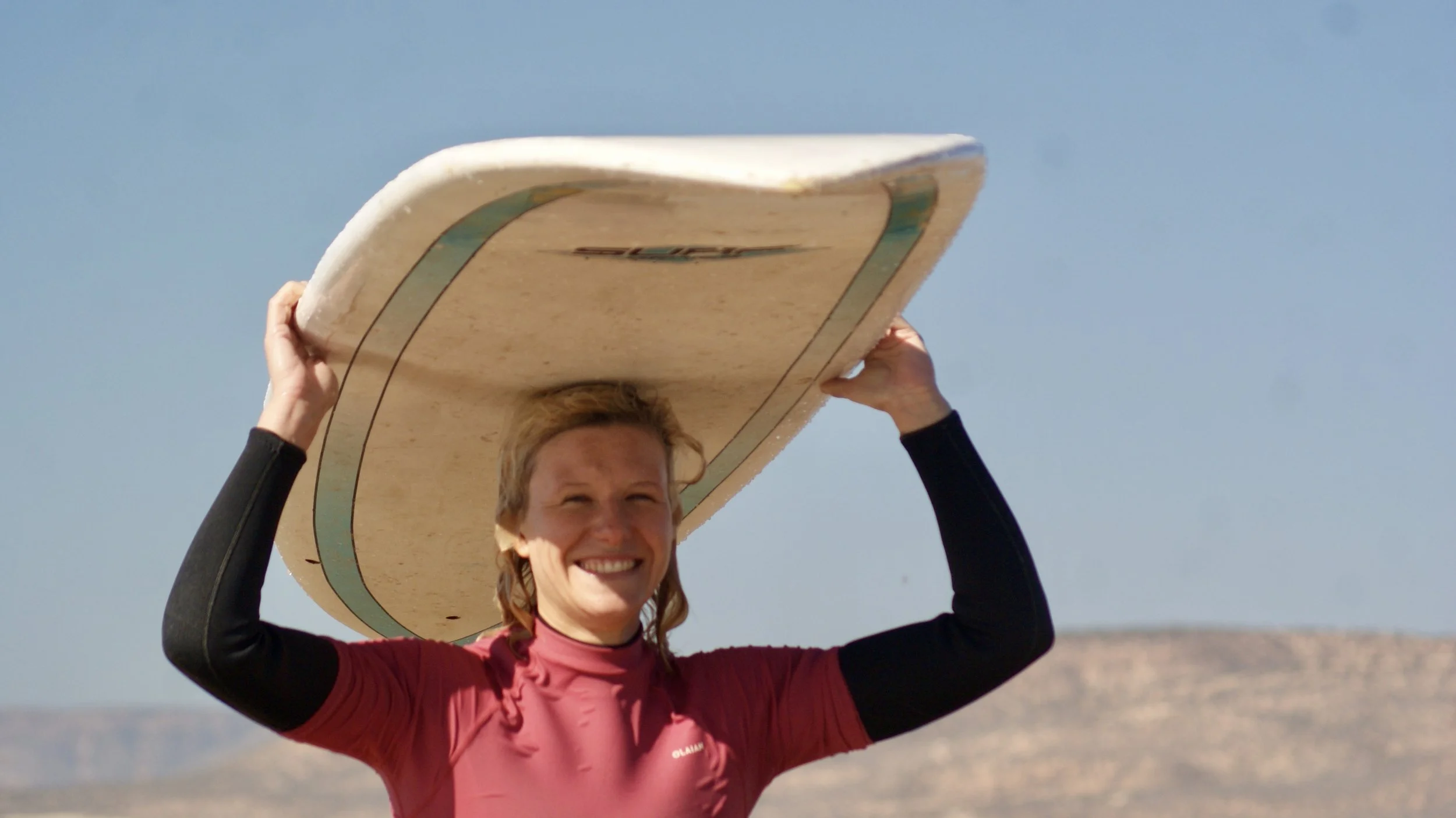 An Intermediate Local Surf Maroc Surfer smiling after a surf session in Taghazout Bay, Morocco.