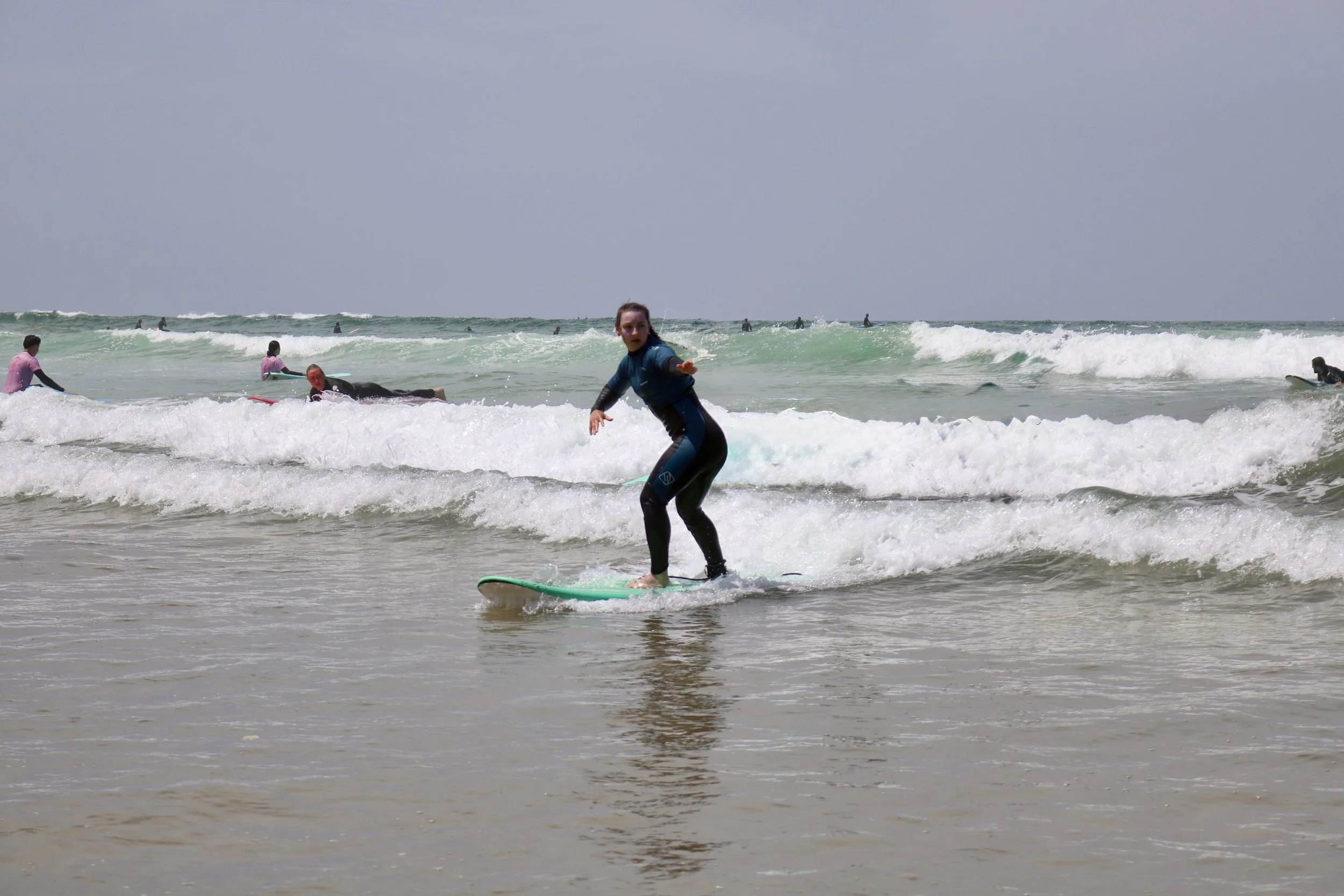 A beginner surfer practicing backside turns in whitewash, Crocros, Tamraght, Morocco