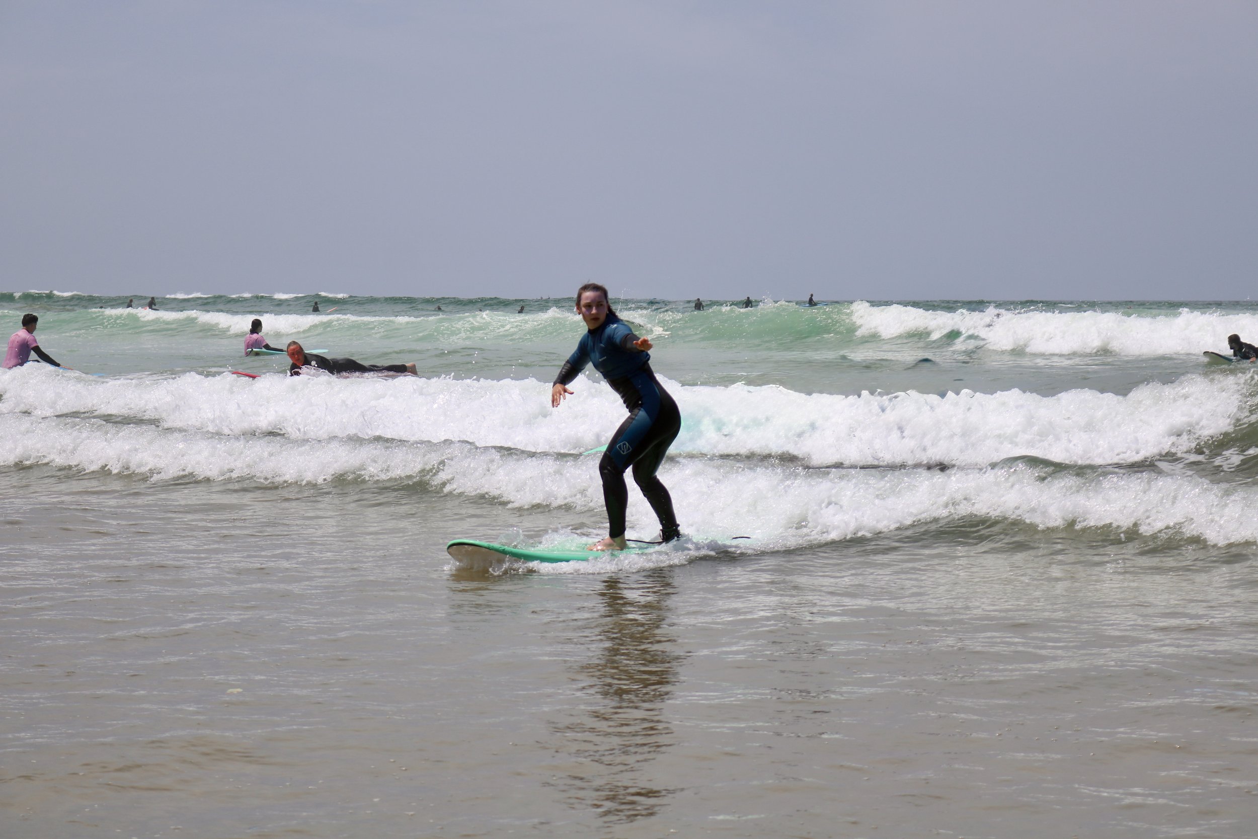 Beginner surfer practicing backside turn in whitewash at Crocros, Tamraght, Morocco