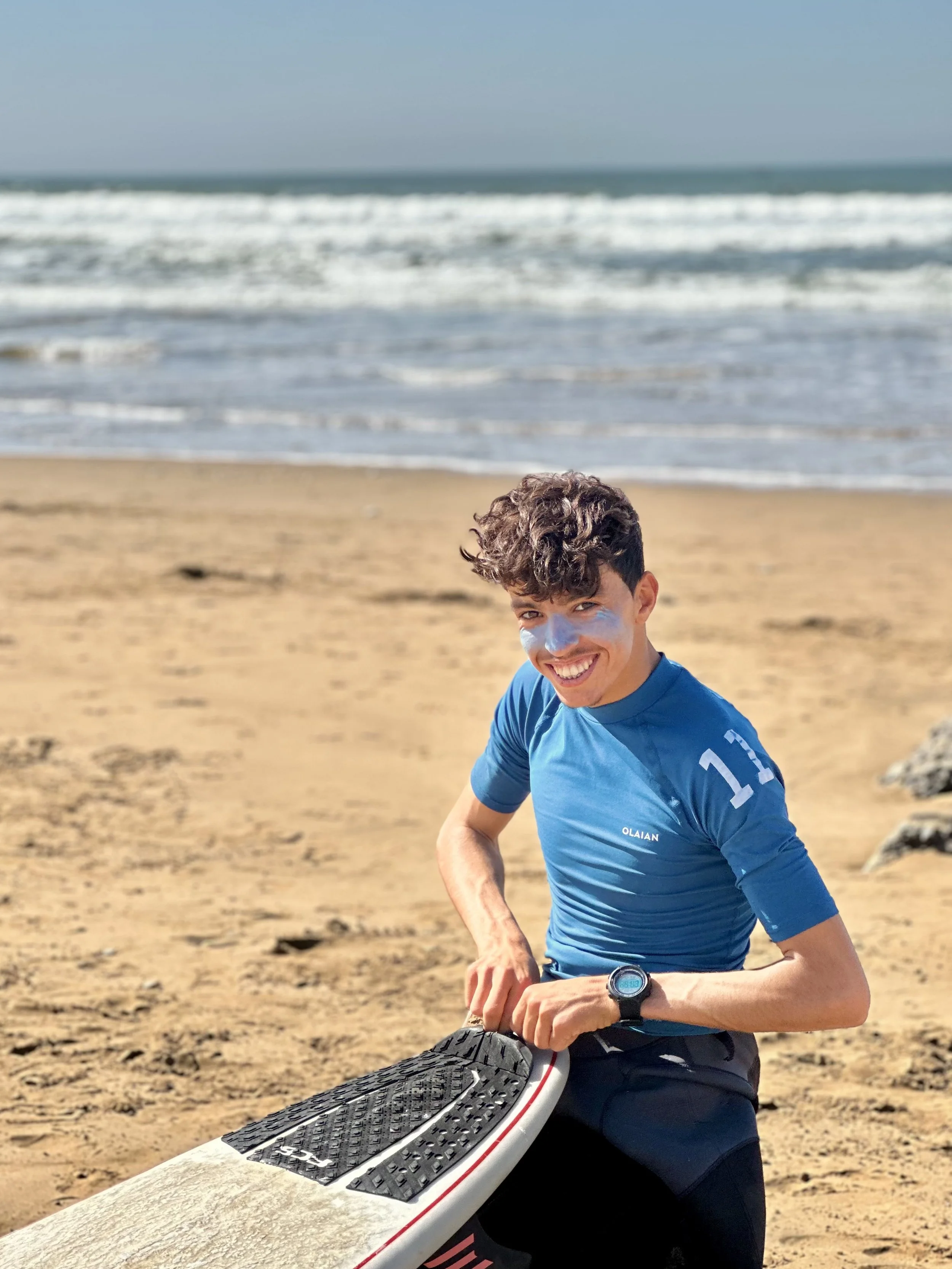 Local Surf Maroc Surf Instructor Mohamed preparing a surf board, Tamraght.