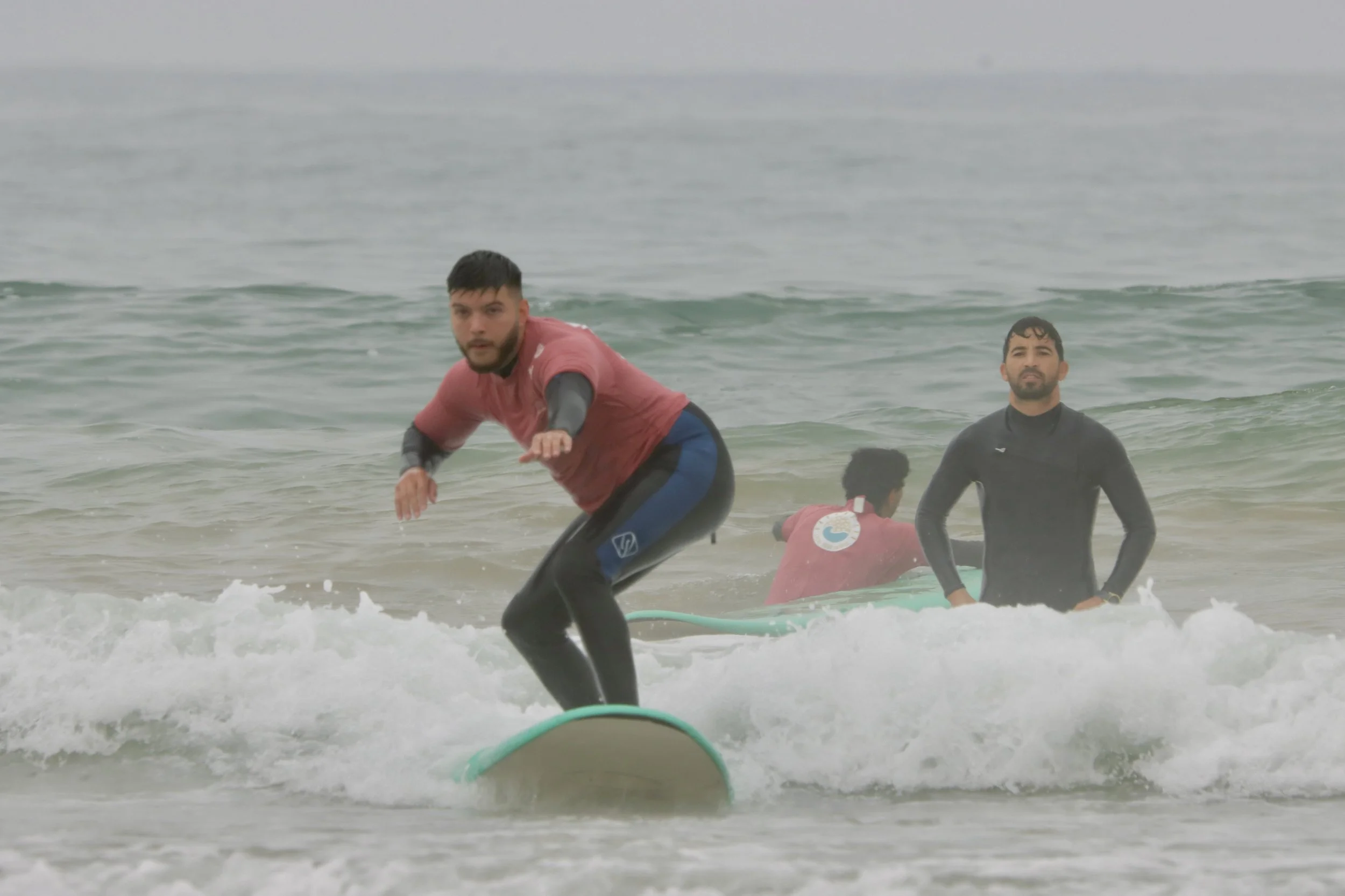A beginner surf ride the washwhite successfully during Surf Coach Khalid's beginner surf lesson in Tamraght, Morocco.
