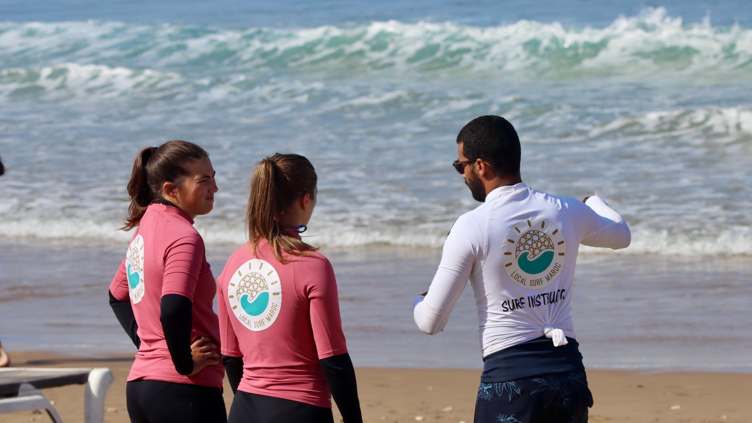 Local Surf Instructor Ayoub providing surf theory wave analysis before paddling out in Tamraght, Morocco