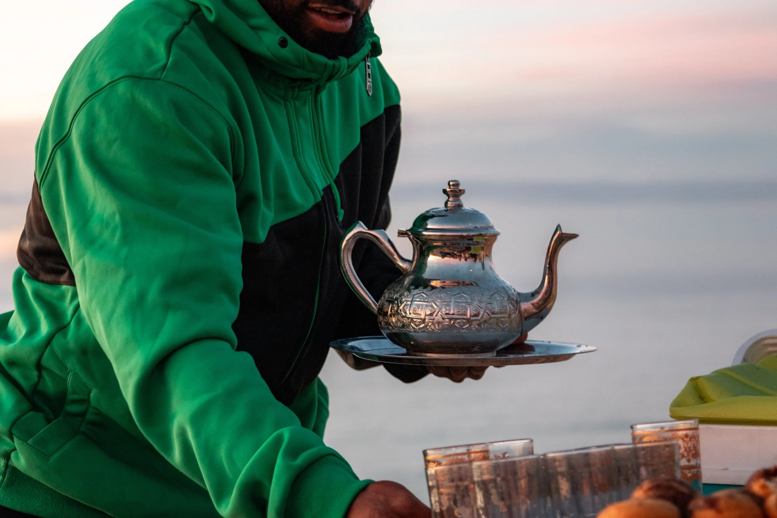 Mint tea being served during sunset at Timlaline sand dunes, Morocco.