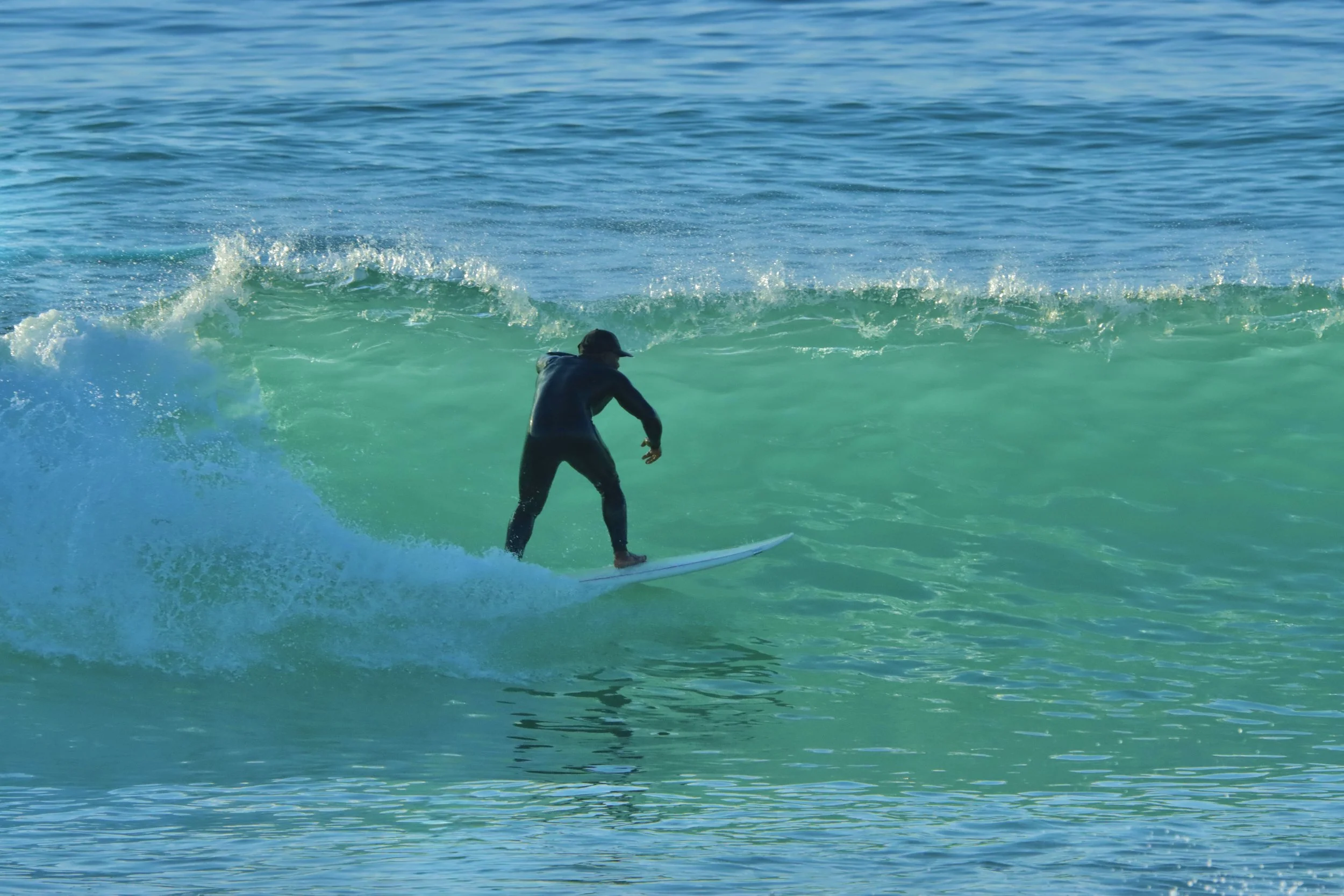 Ayoub, Local Surf Maroc ISA qualified instructor surfing at sunset at Crocros, Tamraght, Morocco.