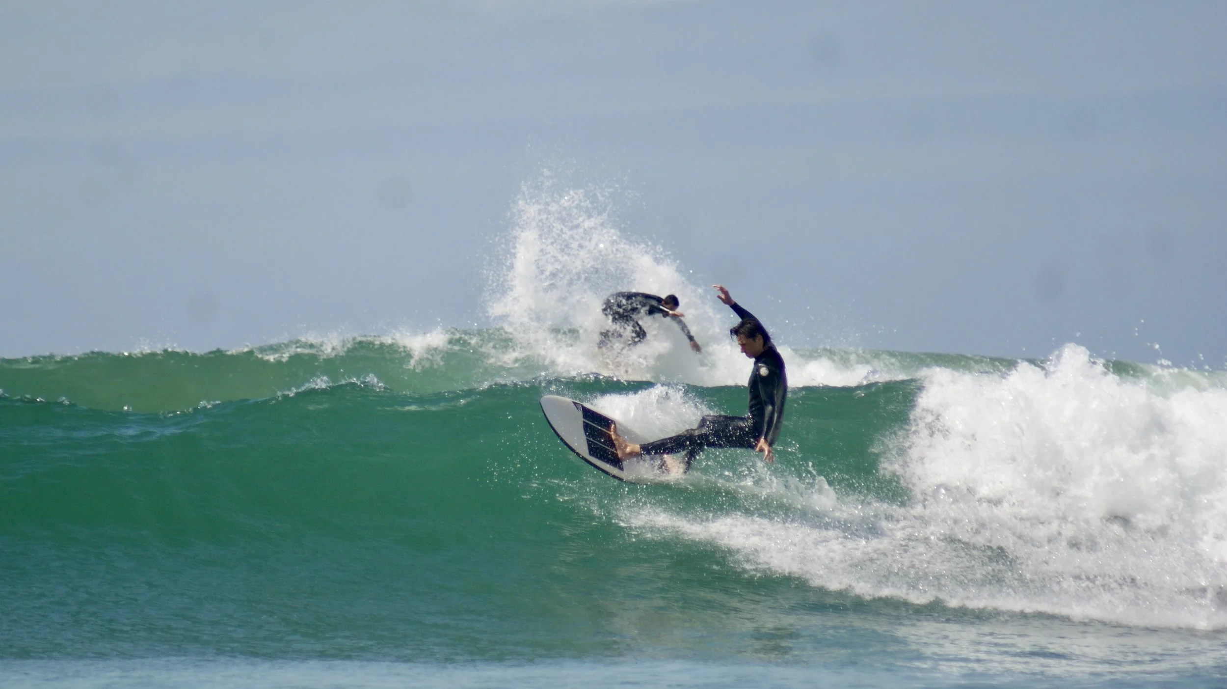 Two surfers on subsequent waves at Mysteries, Taghazout, Morocco.