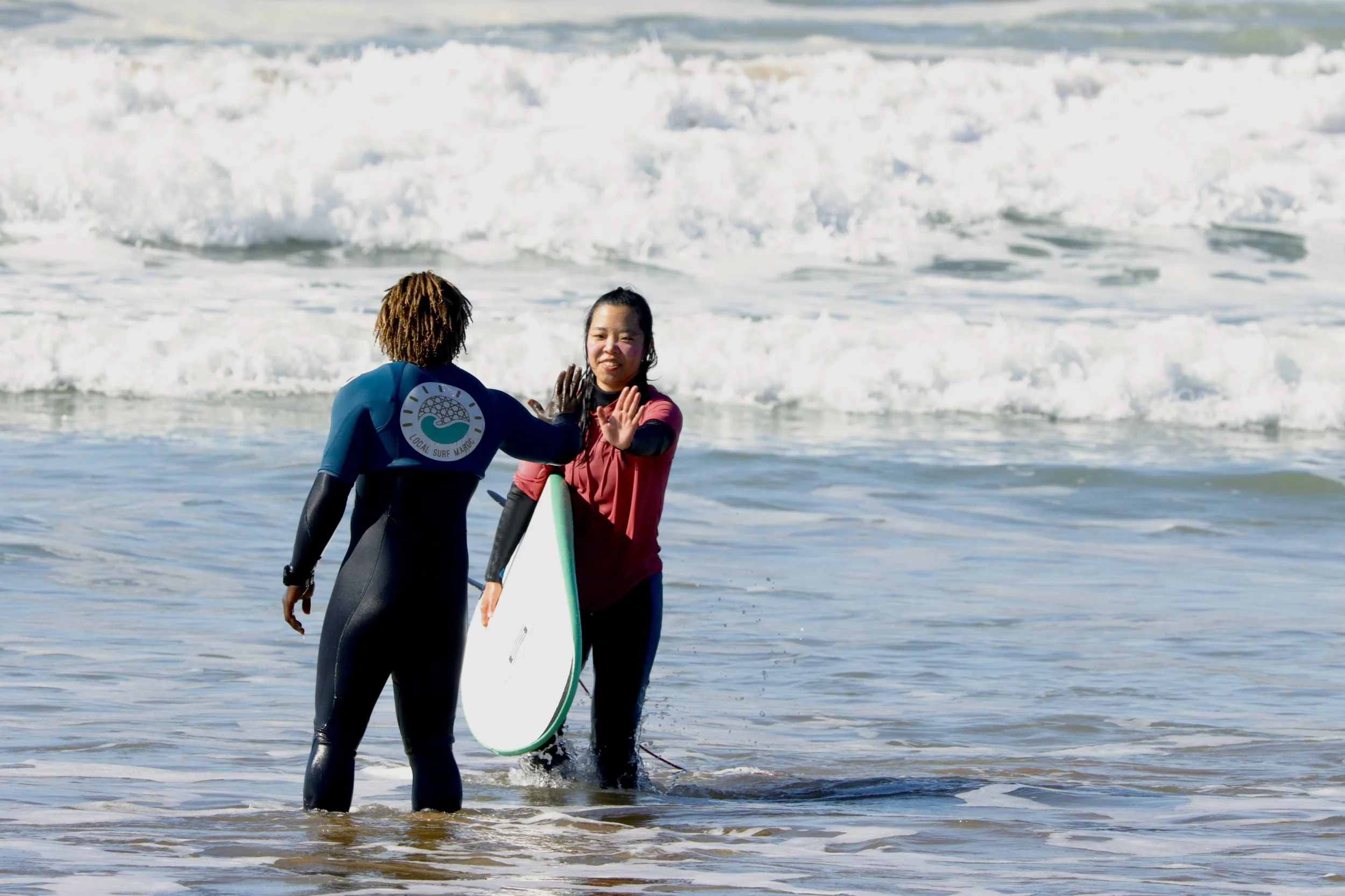 Soulayman giving a high five during a beginner surf lesson, Taghazout, Morocco.