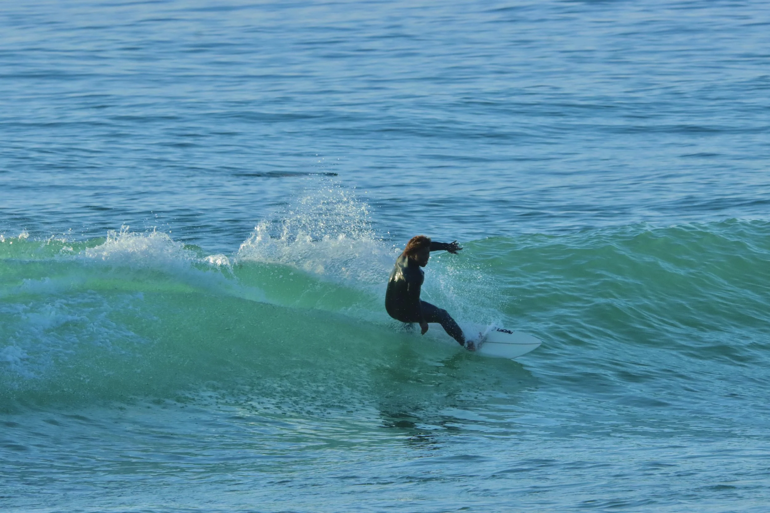 Othmane, Local Surf Maroc instructor surfing sunset at Crocros, Tamraght, Morocco.