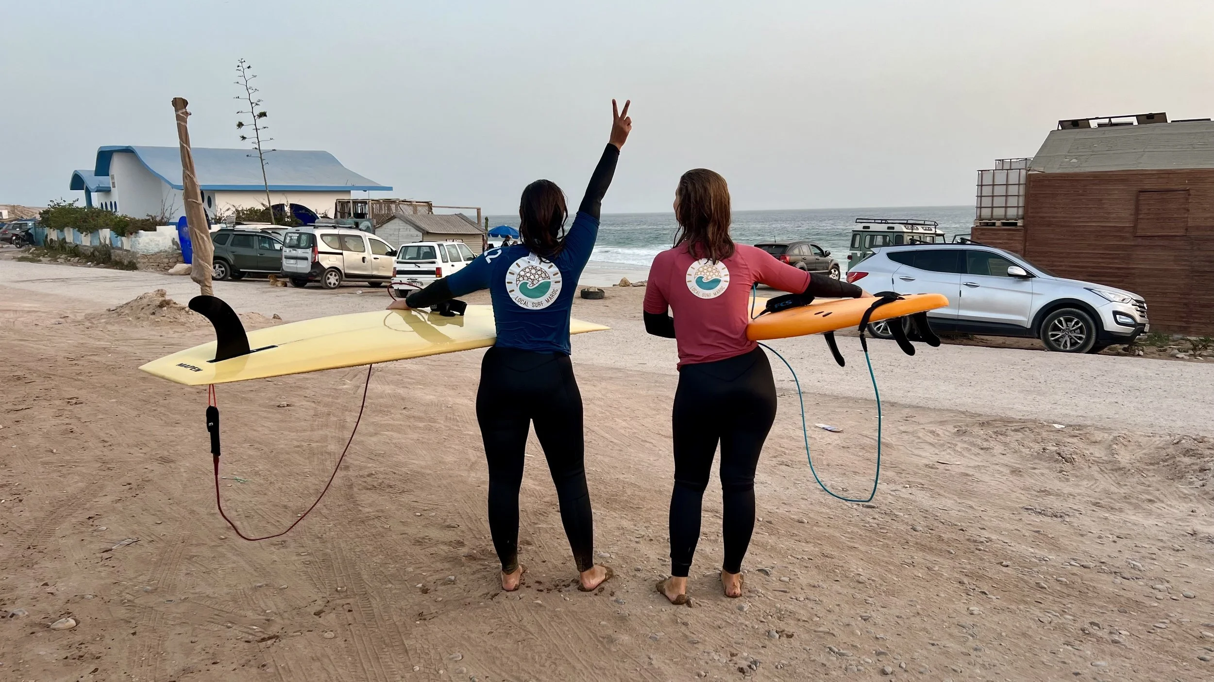 Happy Improver surfers after a sunset surf at Devil's Rock, Imouran, Taghazout Bay, Morocco