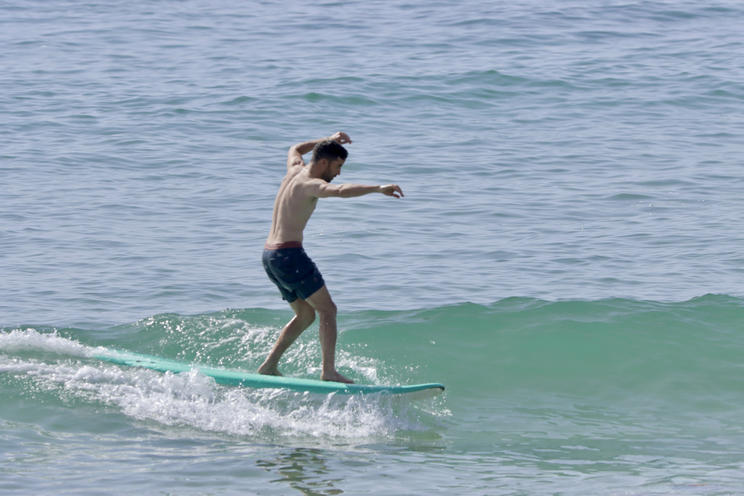 Khalid surfing small waves during the warm summer in Taghazout Bay, Morocco.