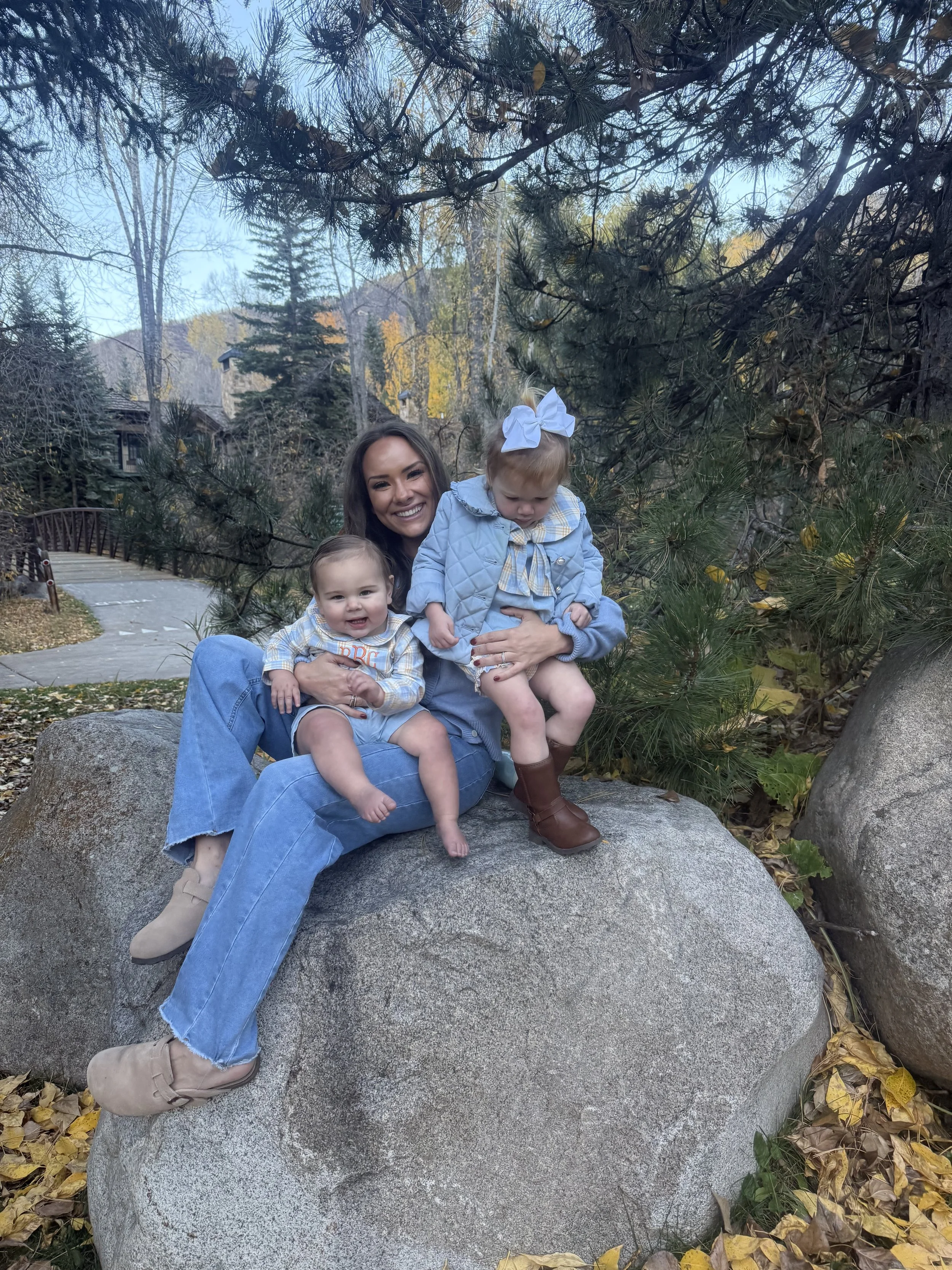 Woman in blue sweater and jeans with her kids in Aspen surrounded by fall leaves