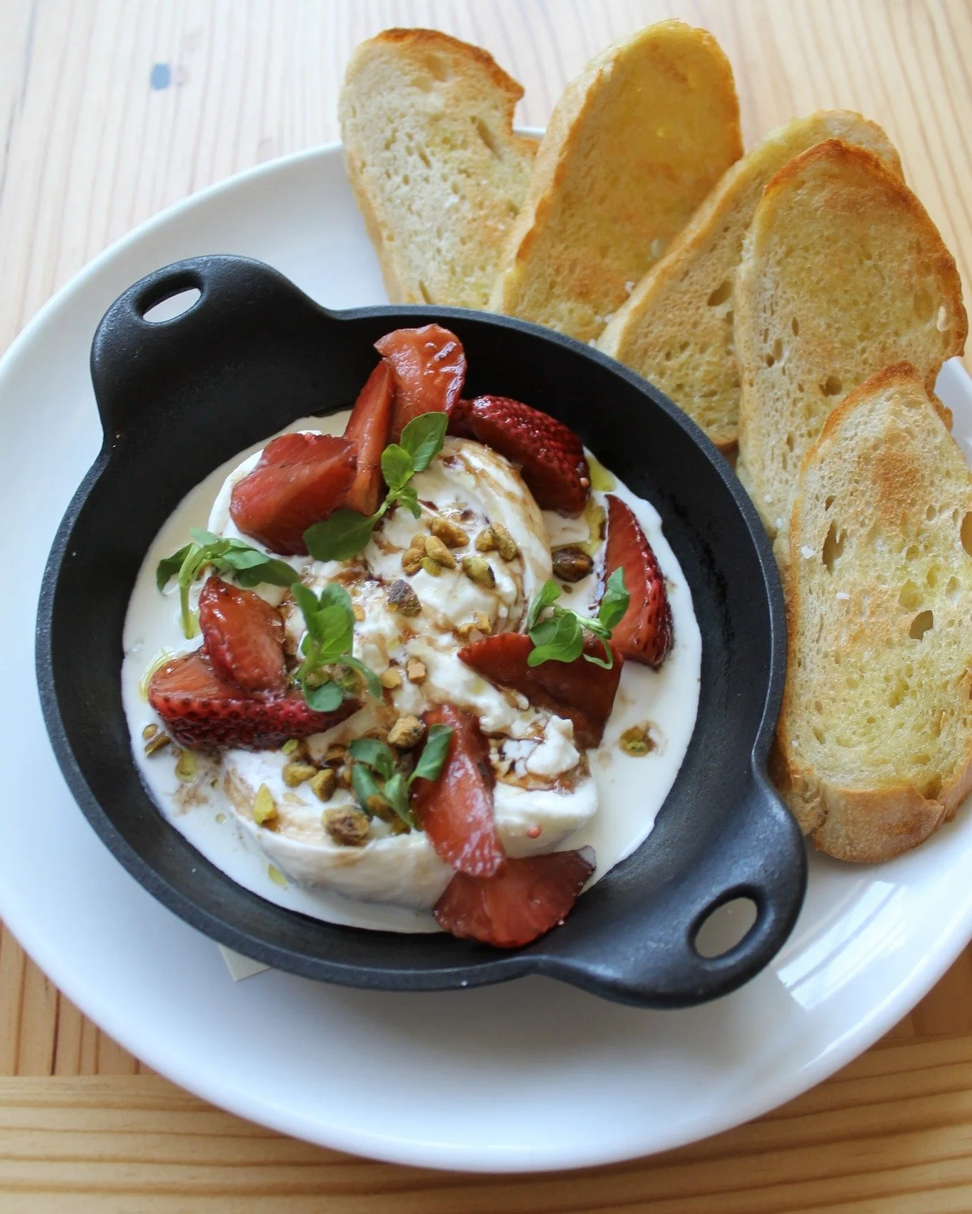 A starter you'll be talking about long after the last bite.

Smoked Burrata ⬩pickled strawberry, pistachio, and strawberry balsamic, with toasted French bread