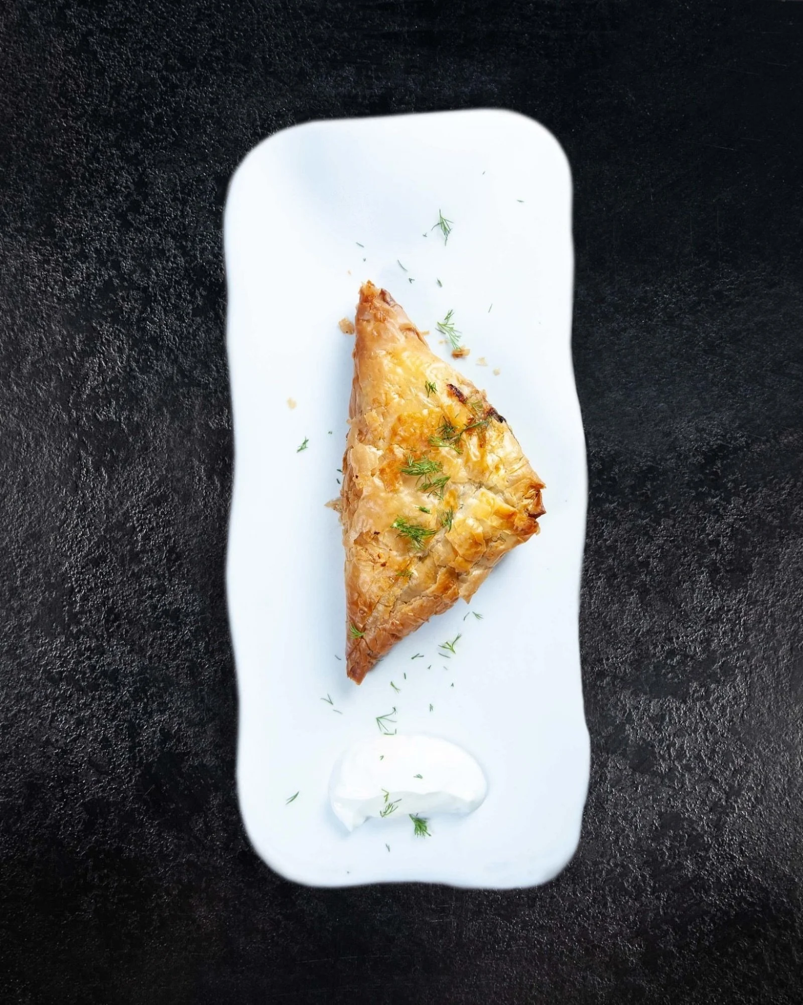 La spanakopita. 🌿
Masa filo, espinacas, puerro, feta, eneldo y aceite de oliva griego. Una receta que no necesita mejoras porque ya es perfecta.
Un tri&aacute;ngulo que resume media cocina griega.
En Kuzina la hacemos como se ha hecho siempre.
Te es